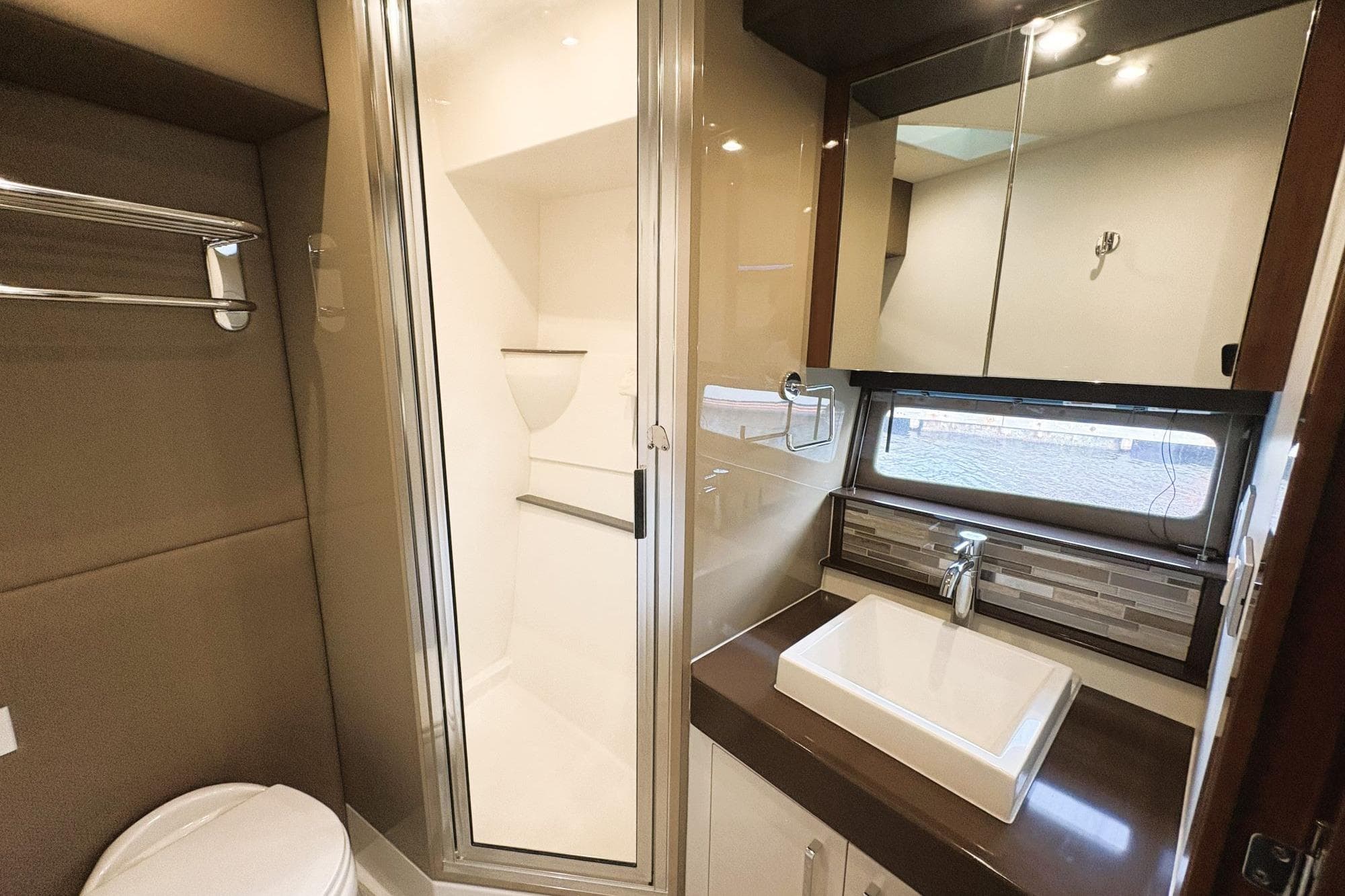 Modern bathroom in 2016 Carver C40 yacht with shower, sink, and mirror.