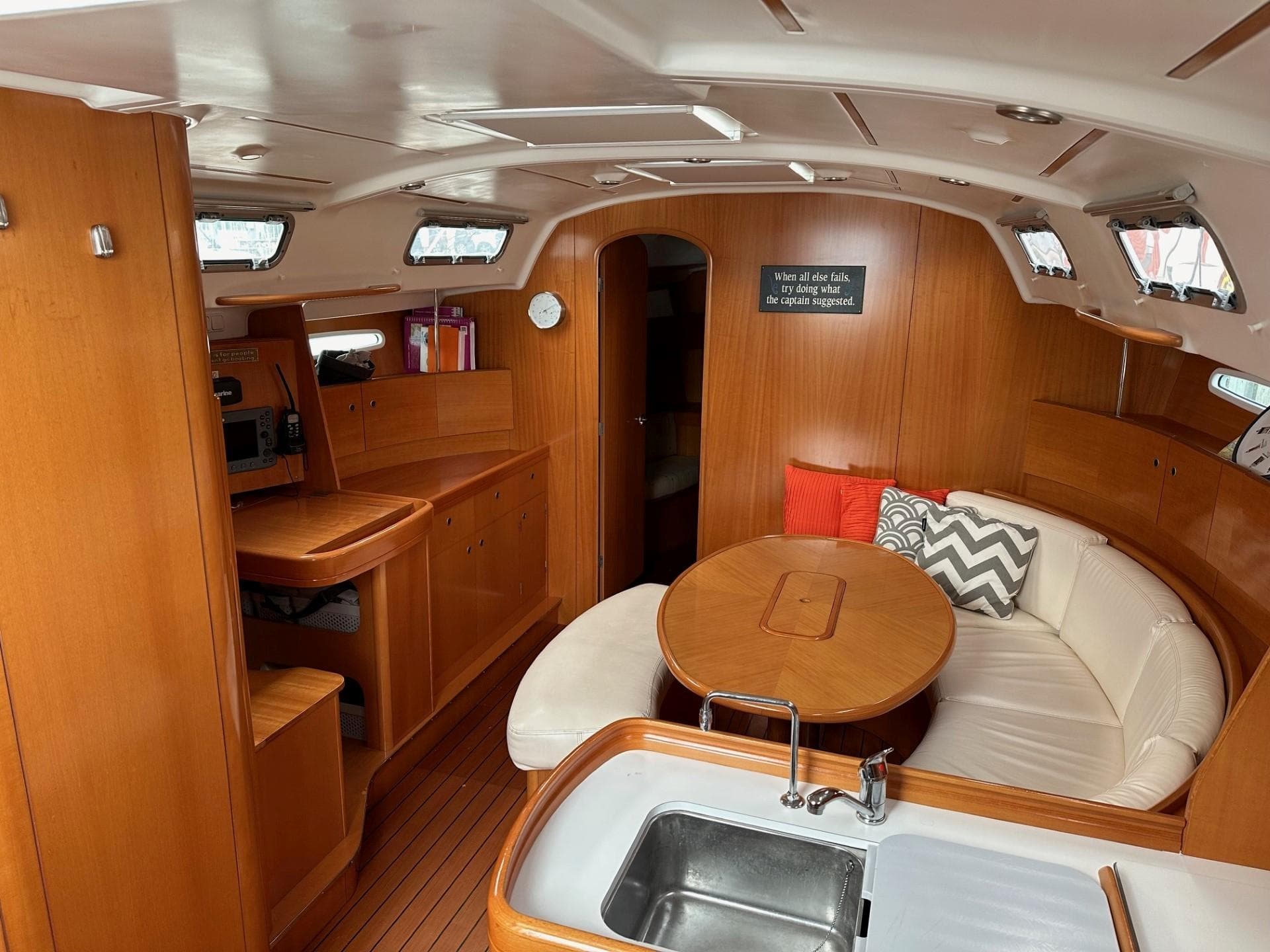 Interior of 2007 Beneteau First 44.7 yacht with wood finish and cozy seating area.
