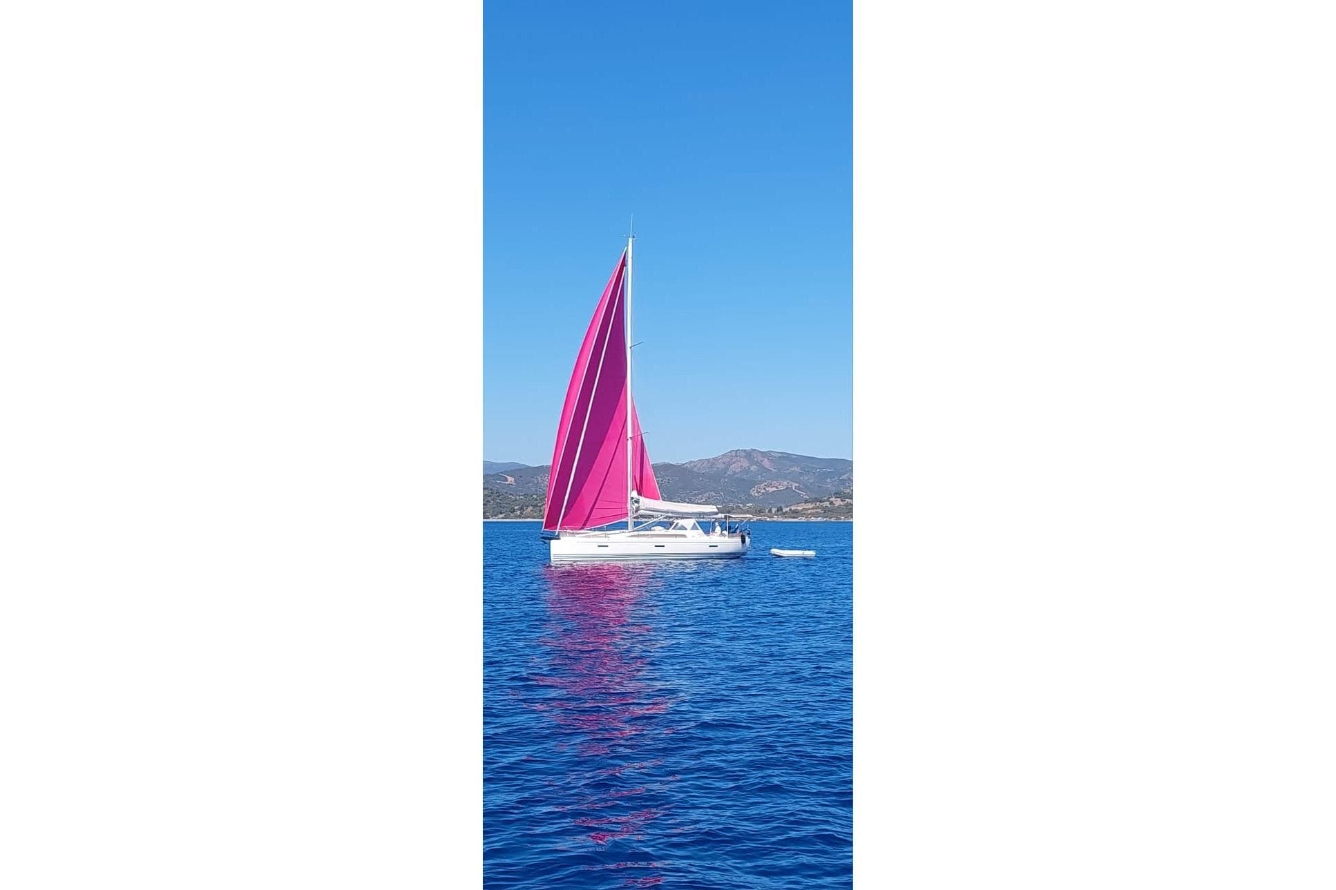 2016 X-Yachts Xp 38 sailboat with vibrant pink sails on blue water.