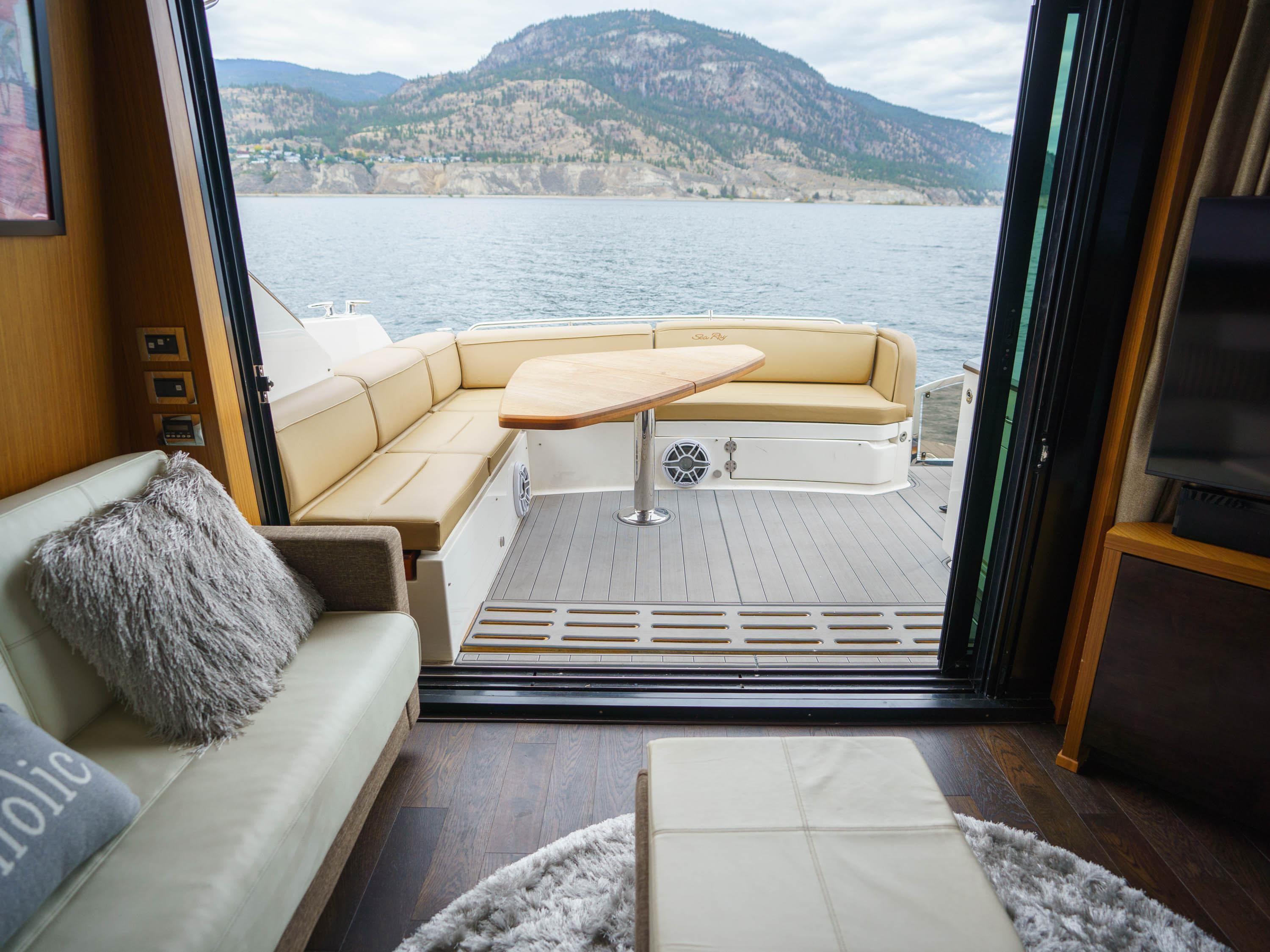 Luxurious 2016 Sea Ray L590 yacht interior with scenic lake and mountain view.