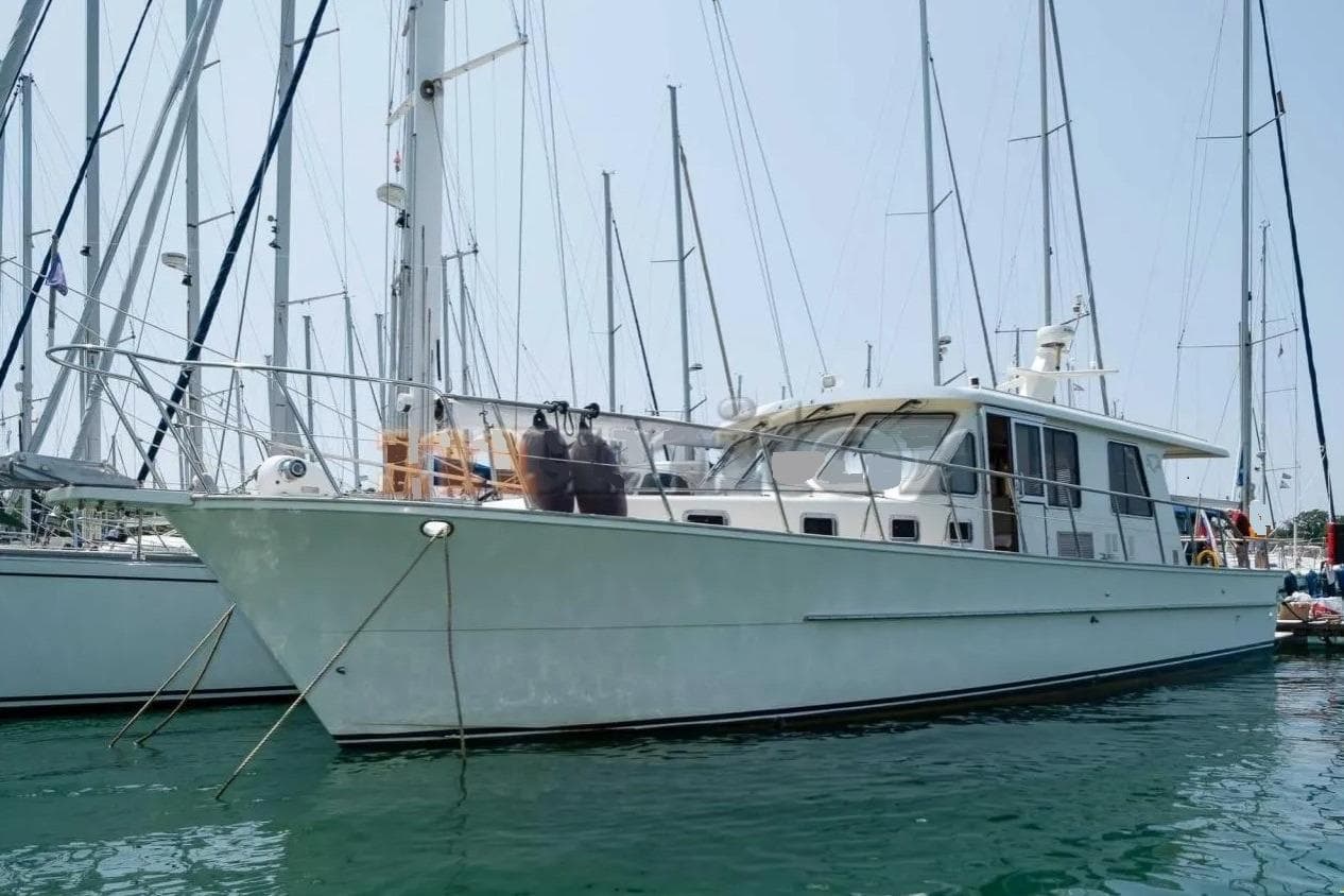 2006 Alaska 45 yacht docked in marina, surrounded by sailboats.