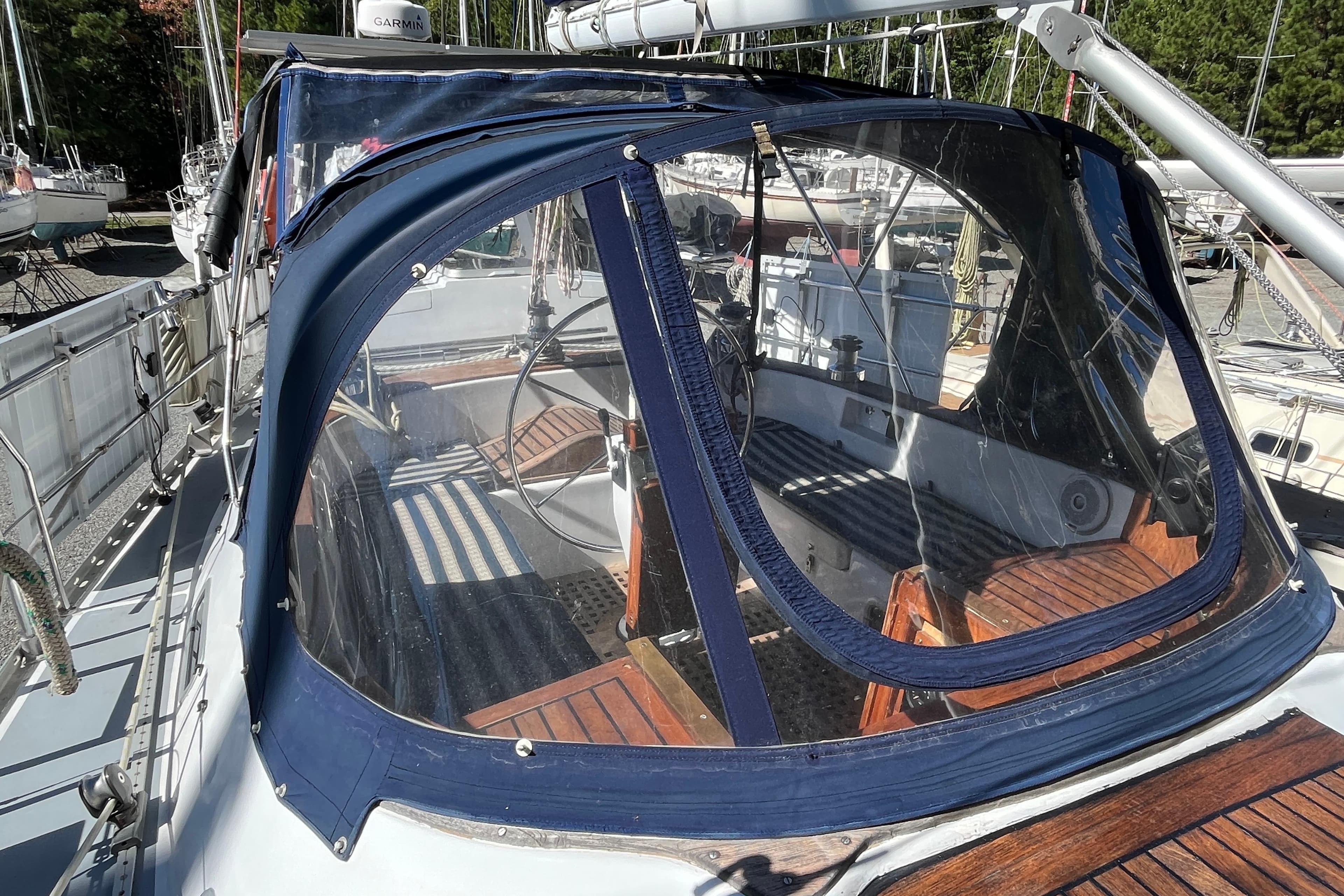 Cockpit of 1993 Med Marine Montevideo 43 sailboat with blue canopy and wooden seating.