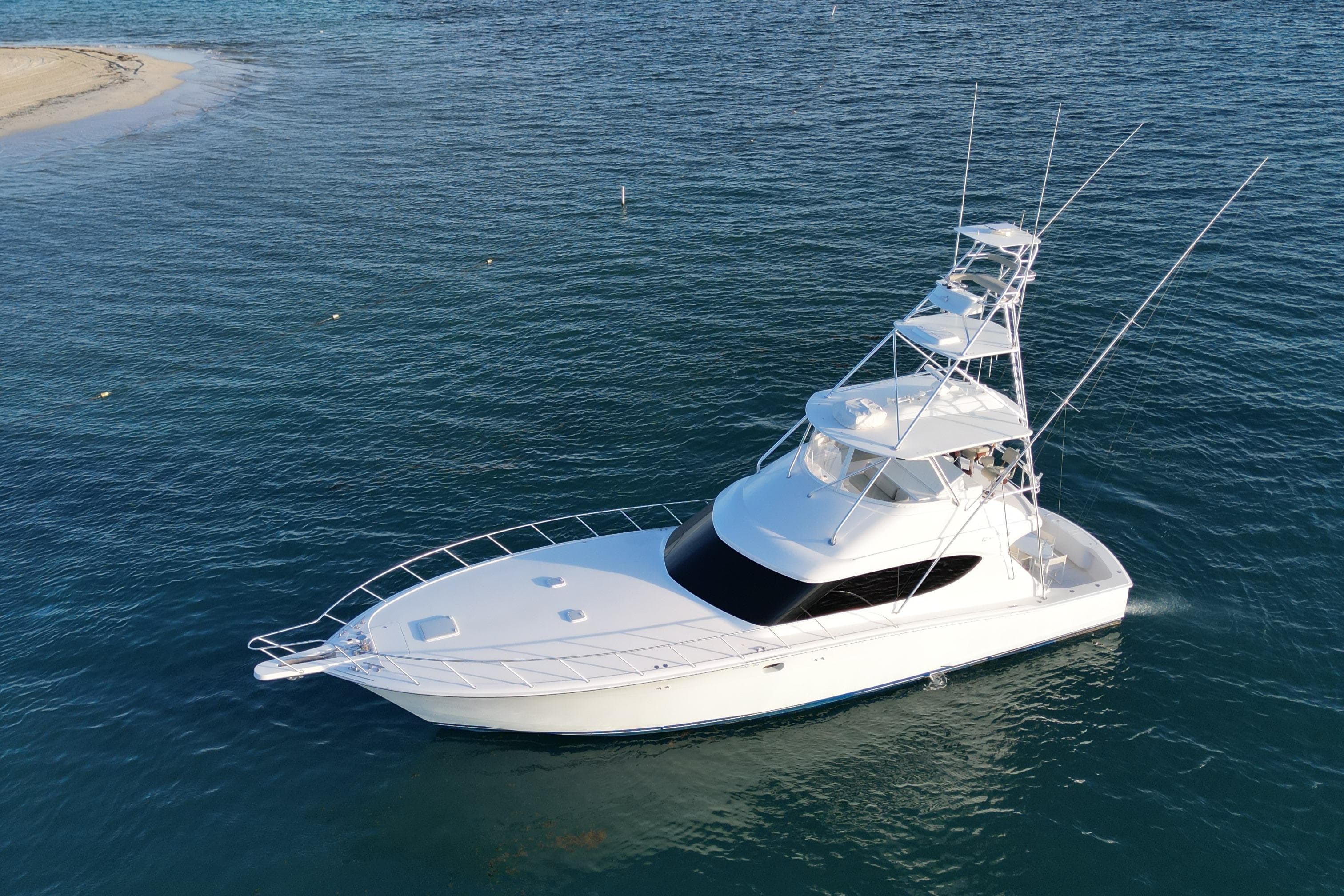 2009 Hatteras 60 Convertible yacht on calm blue water.