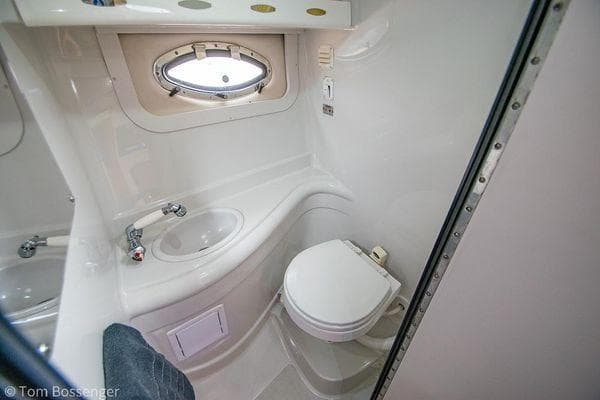 2004 Crownline 250 CR boat bathroom with sink, toilet, and porthole window.