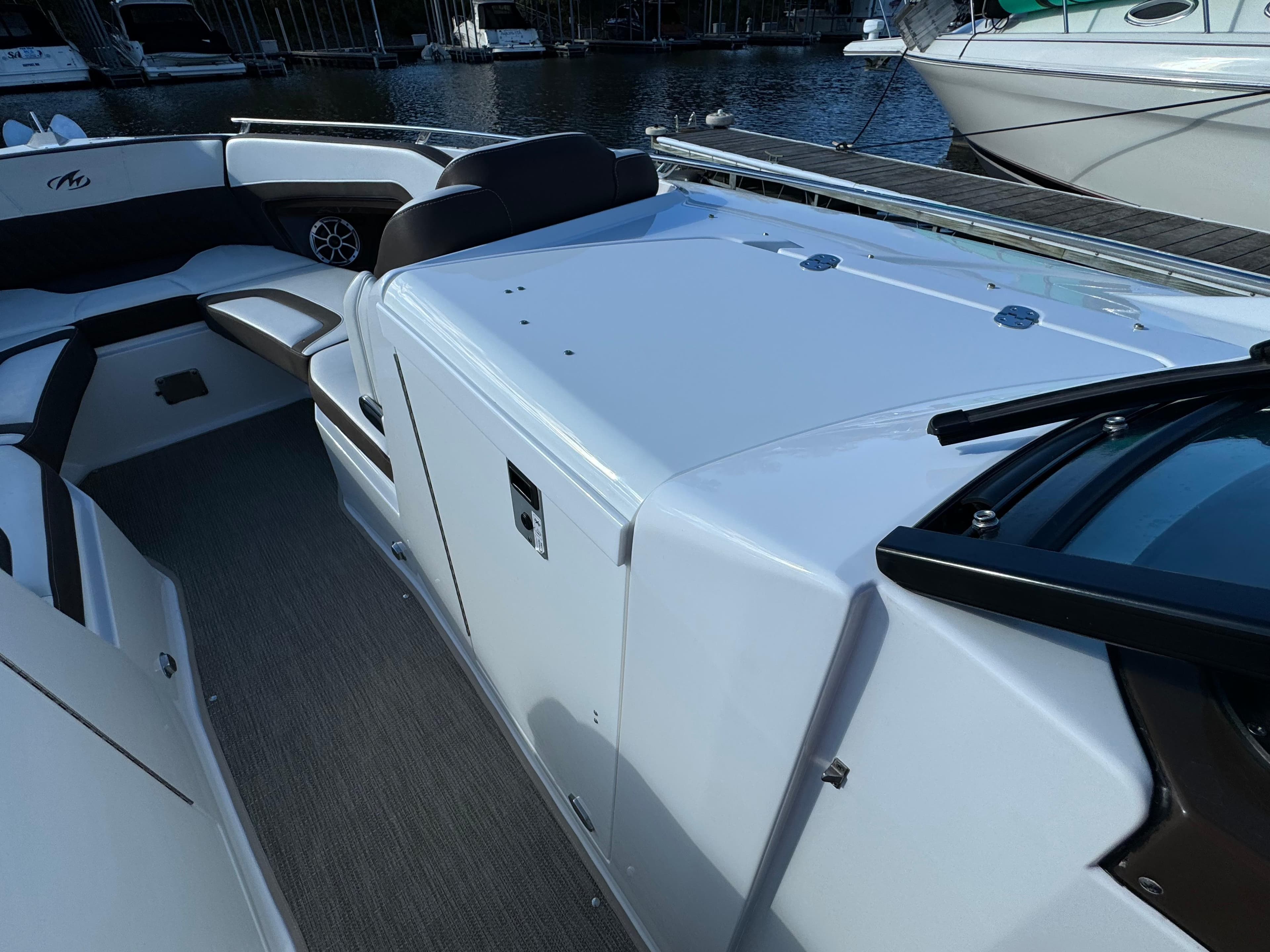 2018 Monterey 328 Super Sport boat interior with seating and storage, docked by the water.
