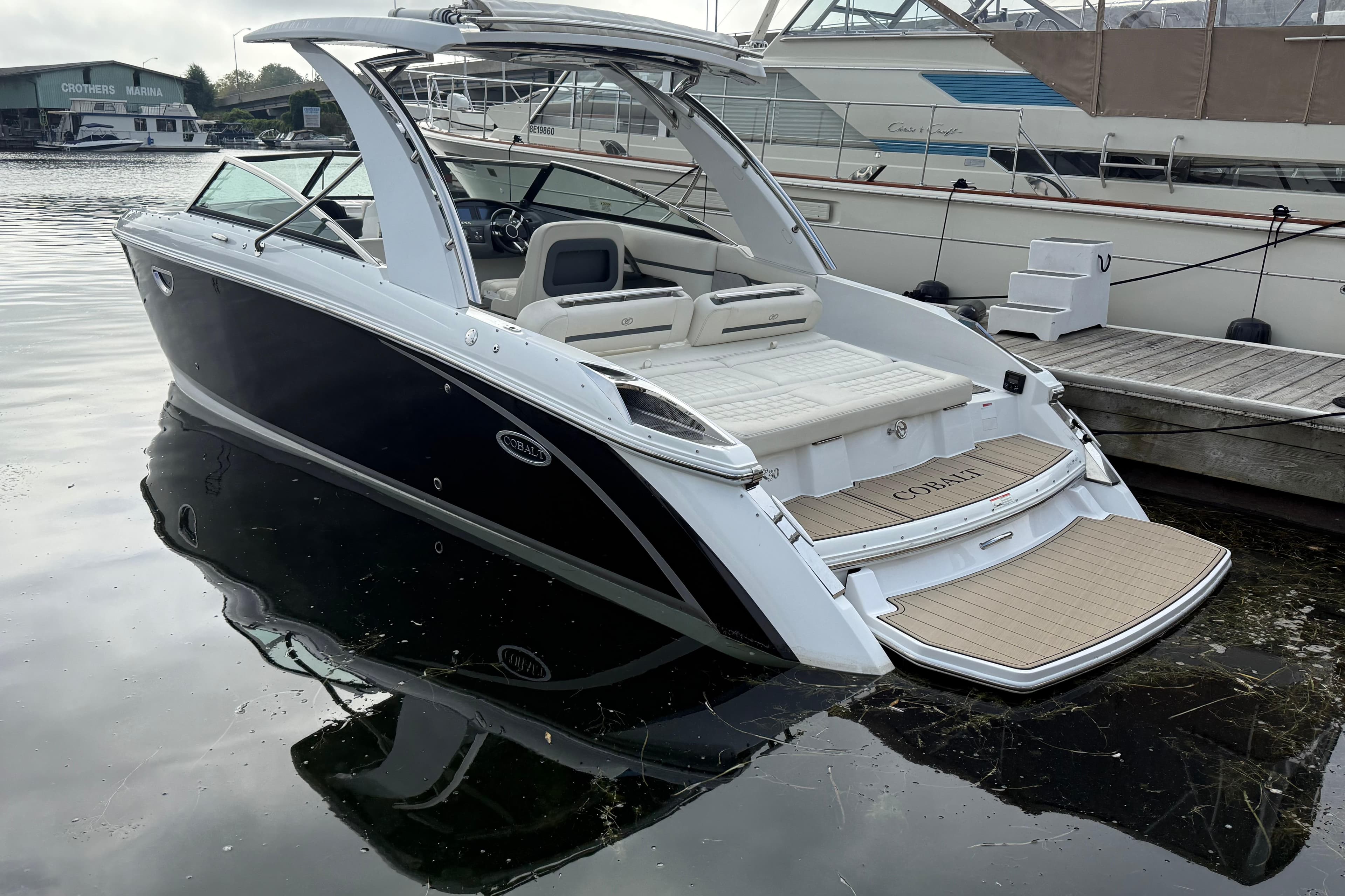 2017 Cobalt R30 boat docked at marina, rear view with open swim platform.