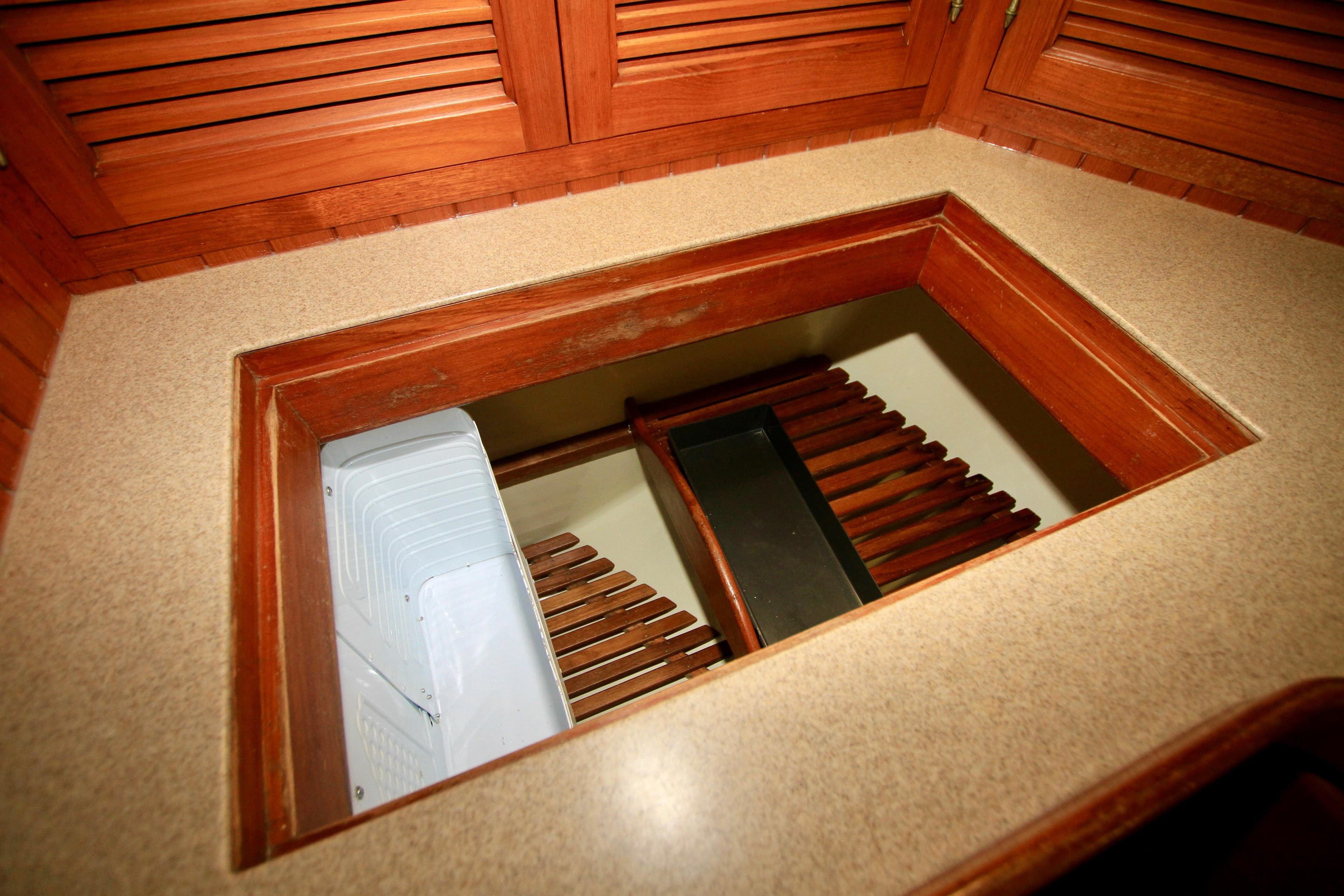 Interior view of 1981 Ta-Shing Panda 40 yacht with wooden cabinetry and storage compartment.