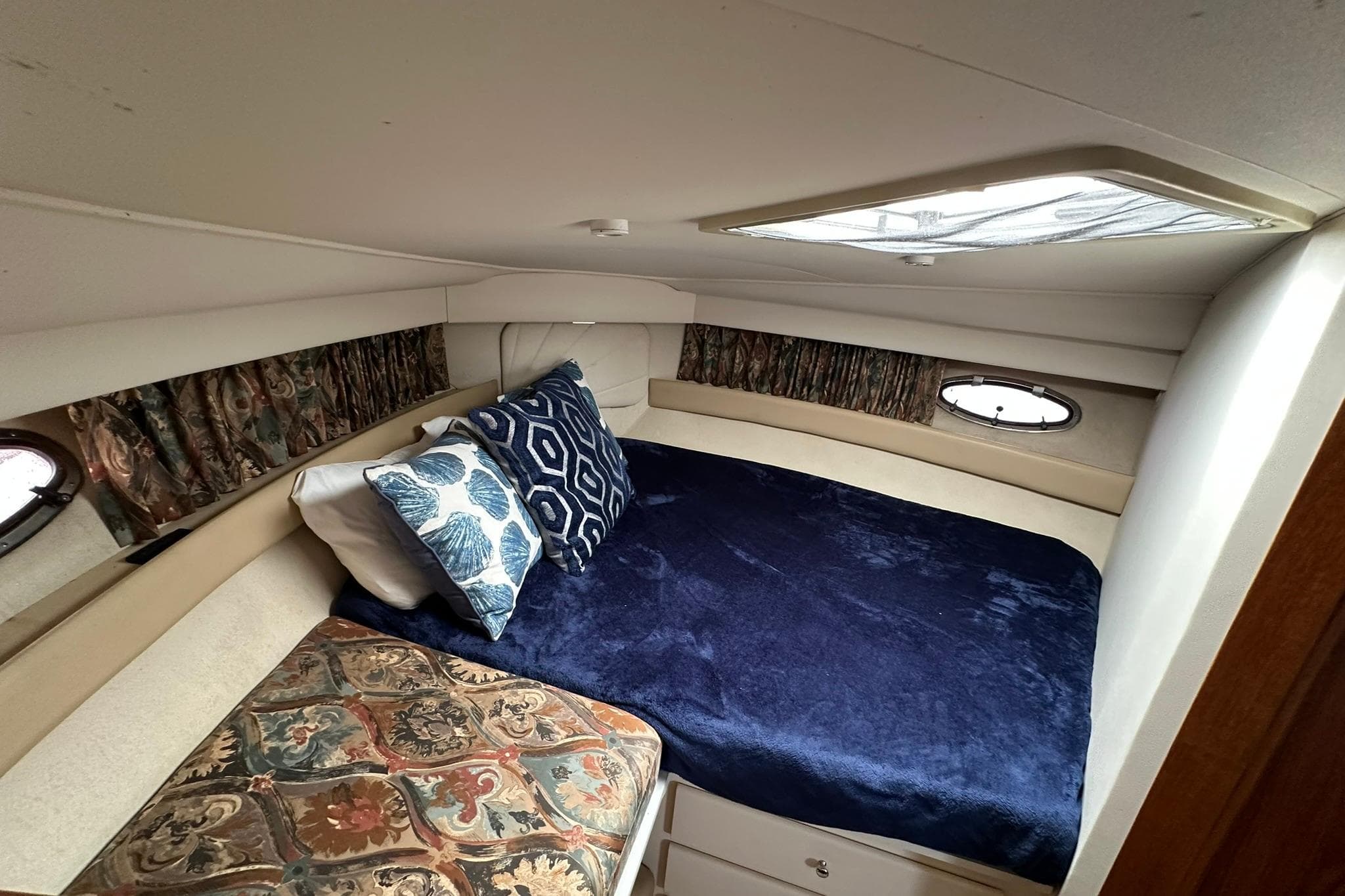 1997 Carver 355 Aft Cabin Motor Yacht bedroom with cozy bedding and decorative pillows.
