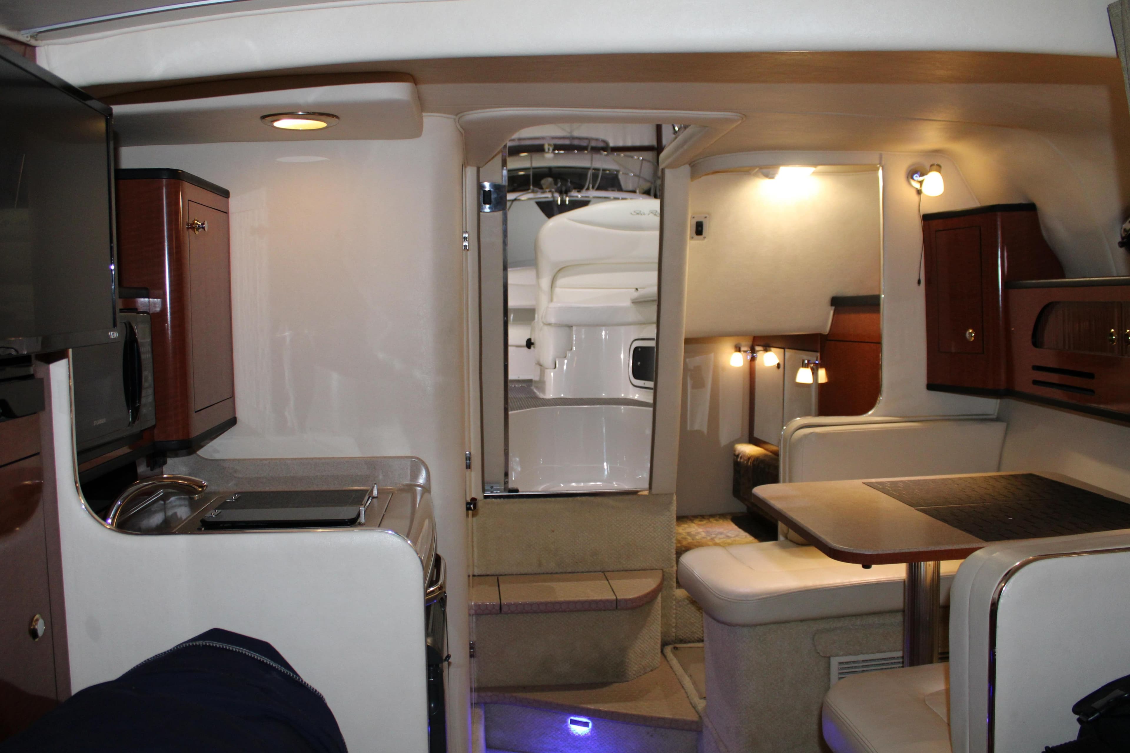 Interior of 2004 Sea Ray Sundancer 280, featuring cozy seating and elegant cabinetry.