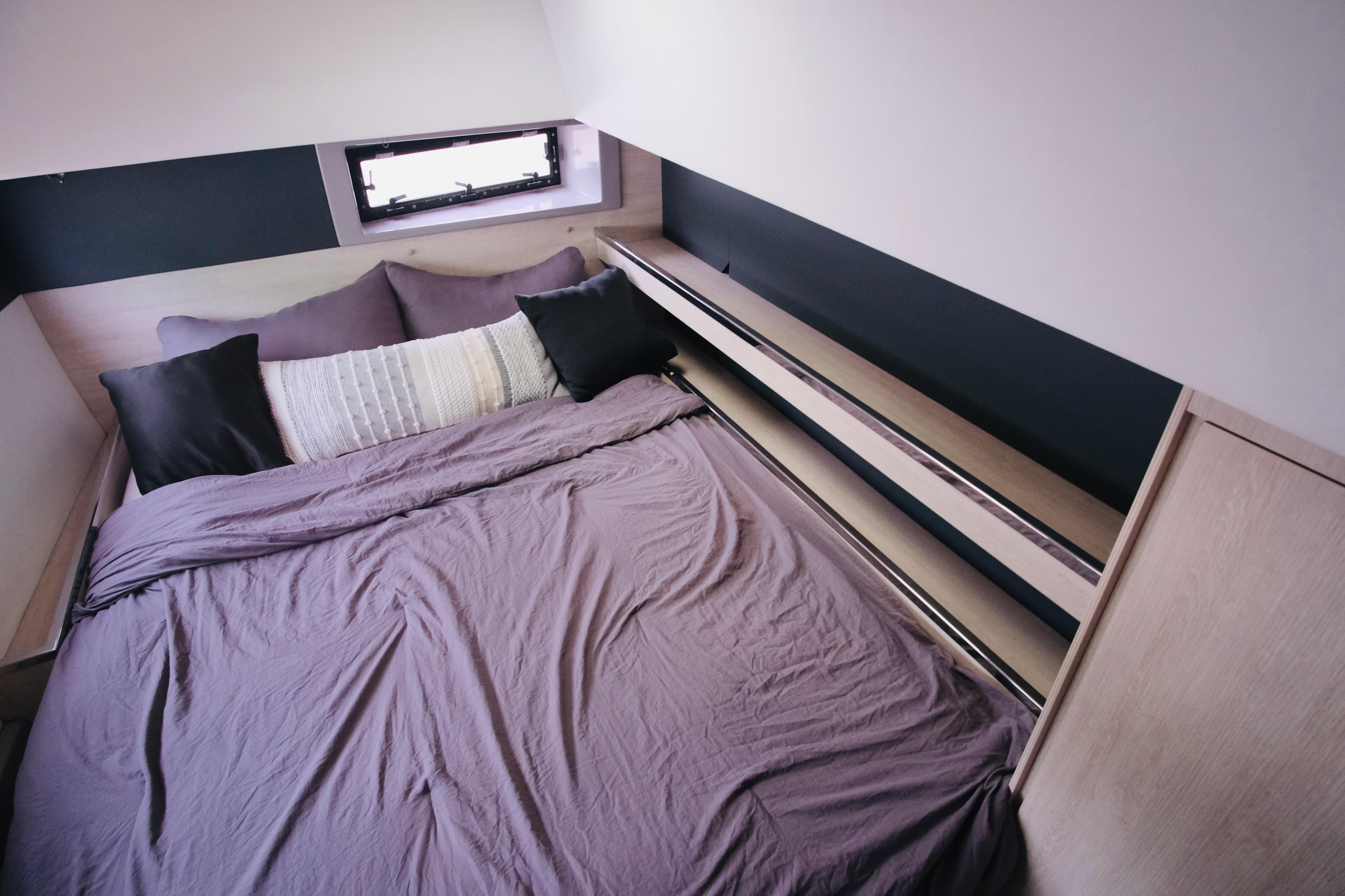 Cozy bedroom in 2018 Leopard 45 yacht with modern bedding and window view.