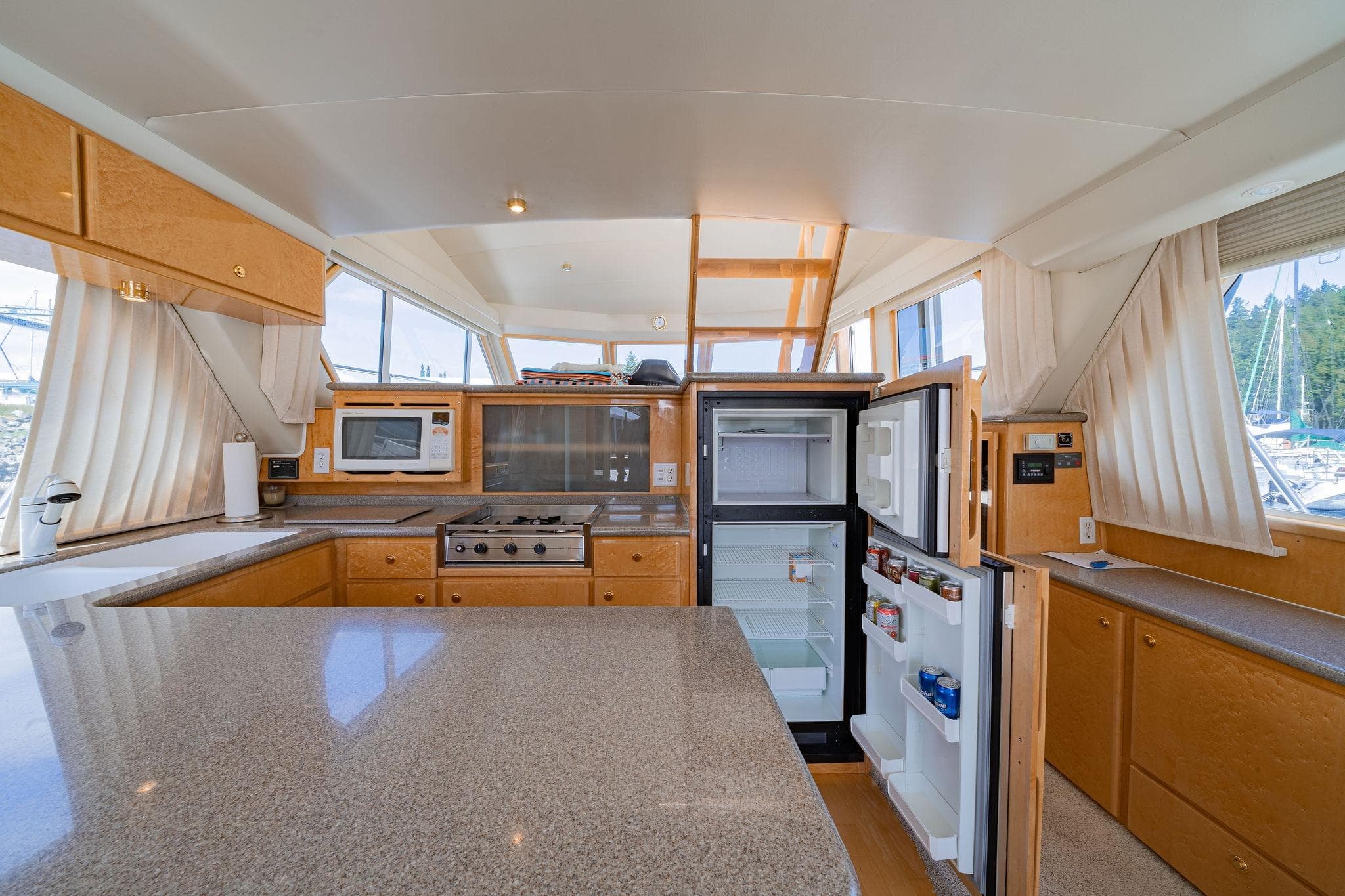 Spacious kitchen on 2000 Navigator 4800 yacht with open fridge, stove, and microwave.