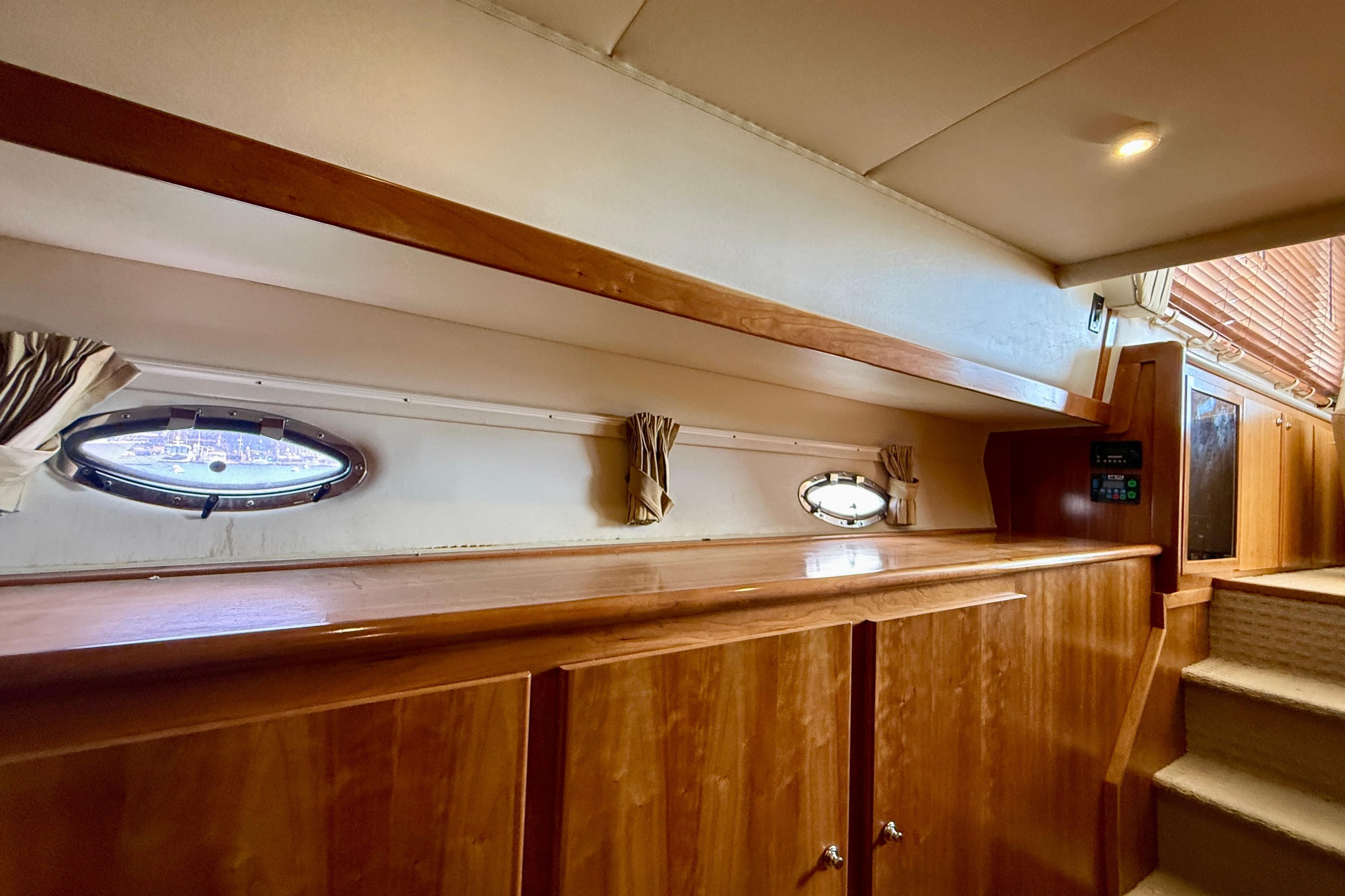 Interior of 2007 Navigator 44 Classic yacht with wooden cabinetry and porthole windows.