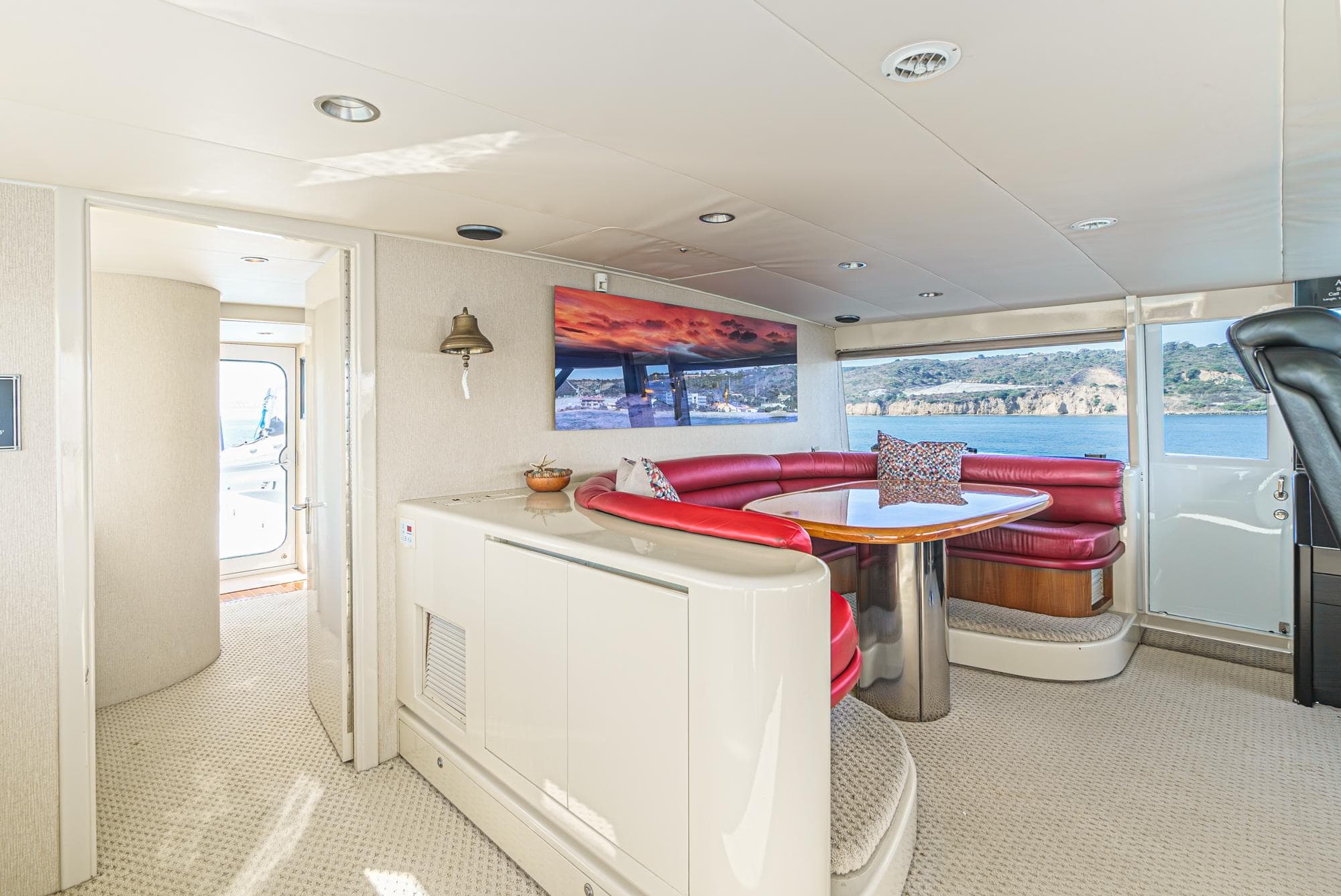 Luxurious 1992 Barattucci Yacht Fisher interior with red seating and scenic ocean view.