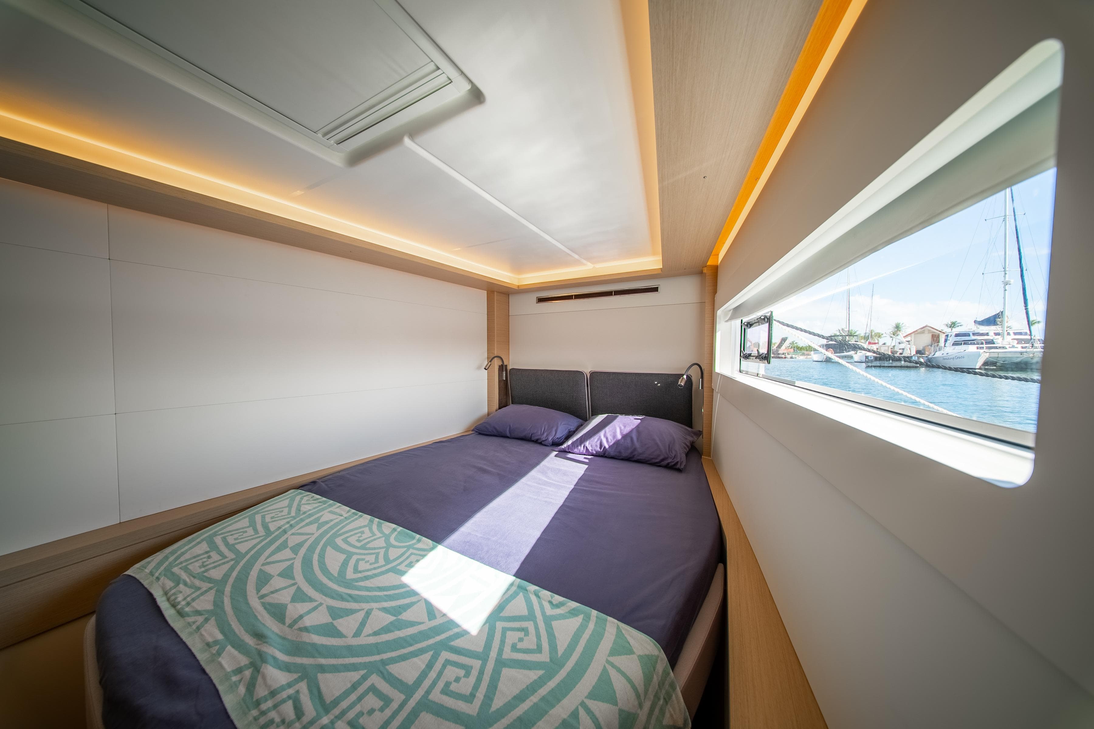 Luxurious cabin interior of 2023 Lagoon 46 yacht with modern design and waterfront view.