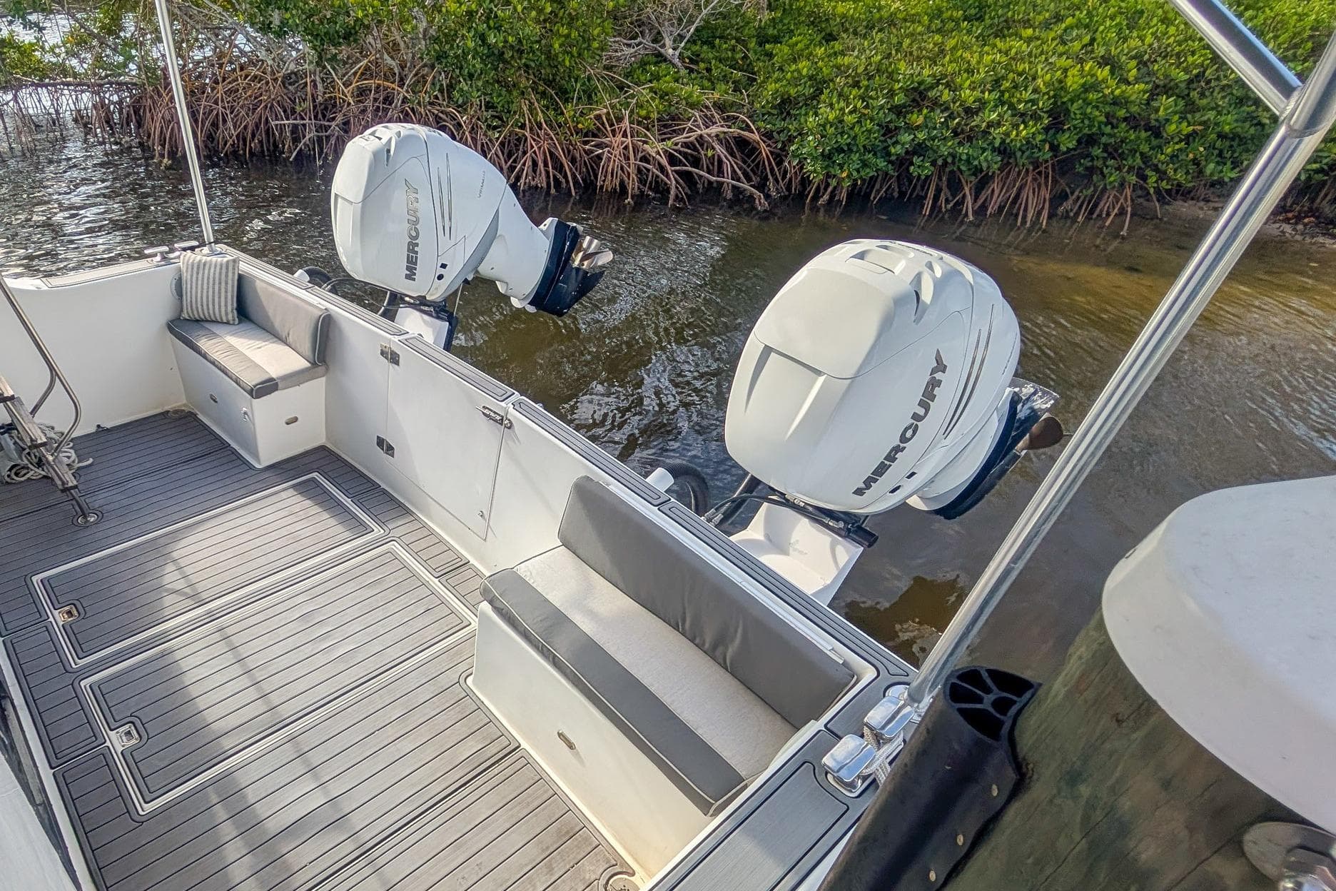 1987 Bluewater Yachts 51 Coastal Cruiser Cockpit with Mercury outboard engines, docked near mangroves.