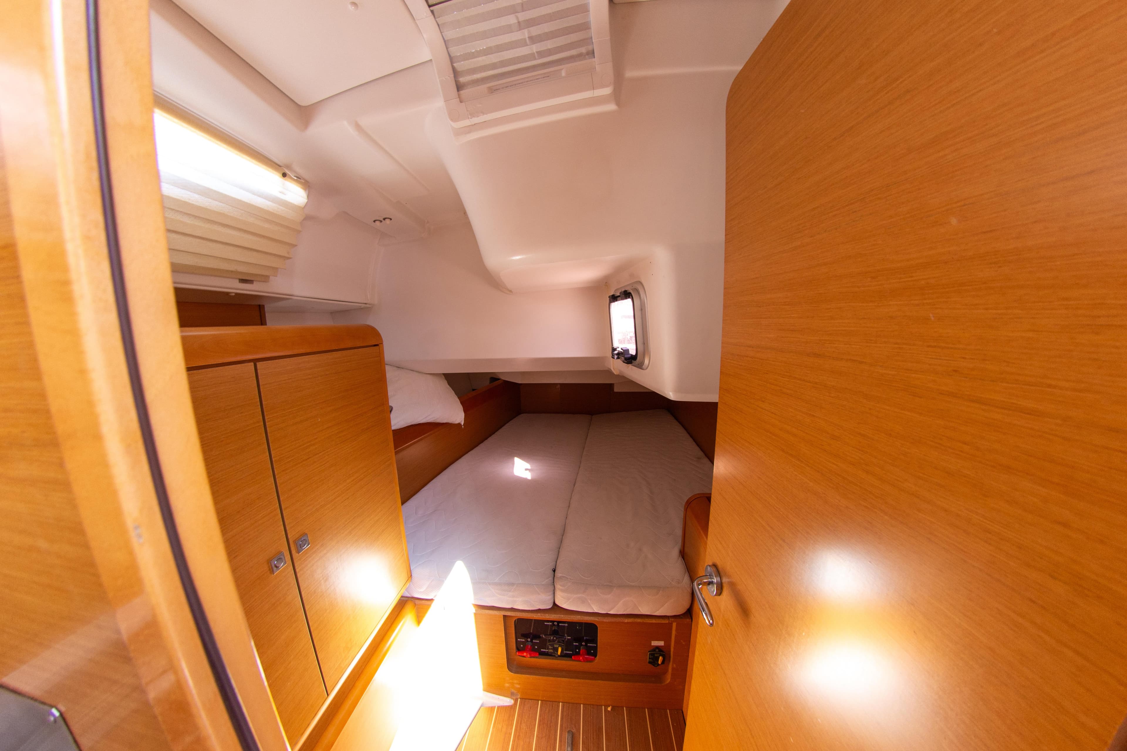 Cozy cabin interior of 2012 Jeanneau Sun Odyssey 439 sailboat with wooden finishes.