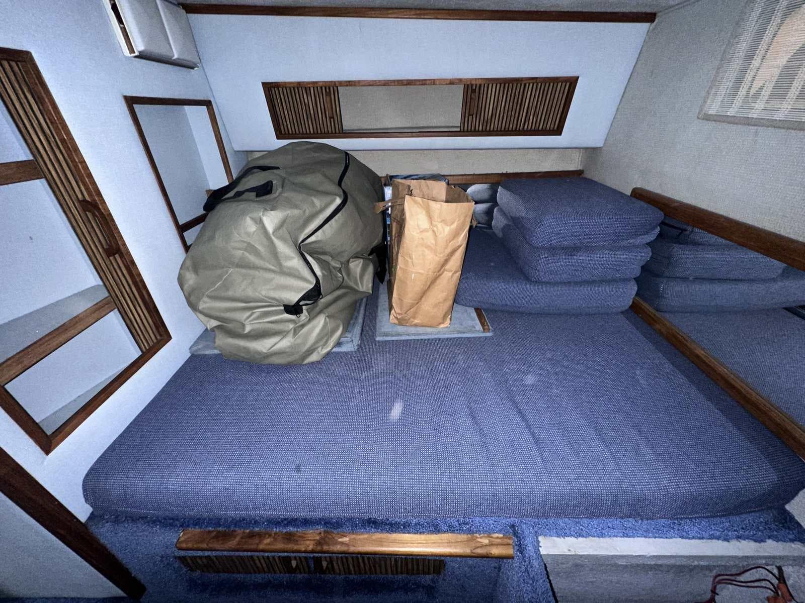 1987 Sea Ray 270 Sundancer cabin interior with blue cushions and storage items.