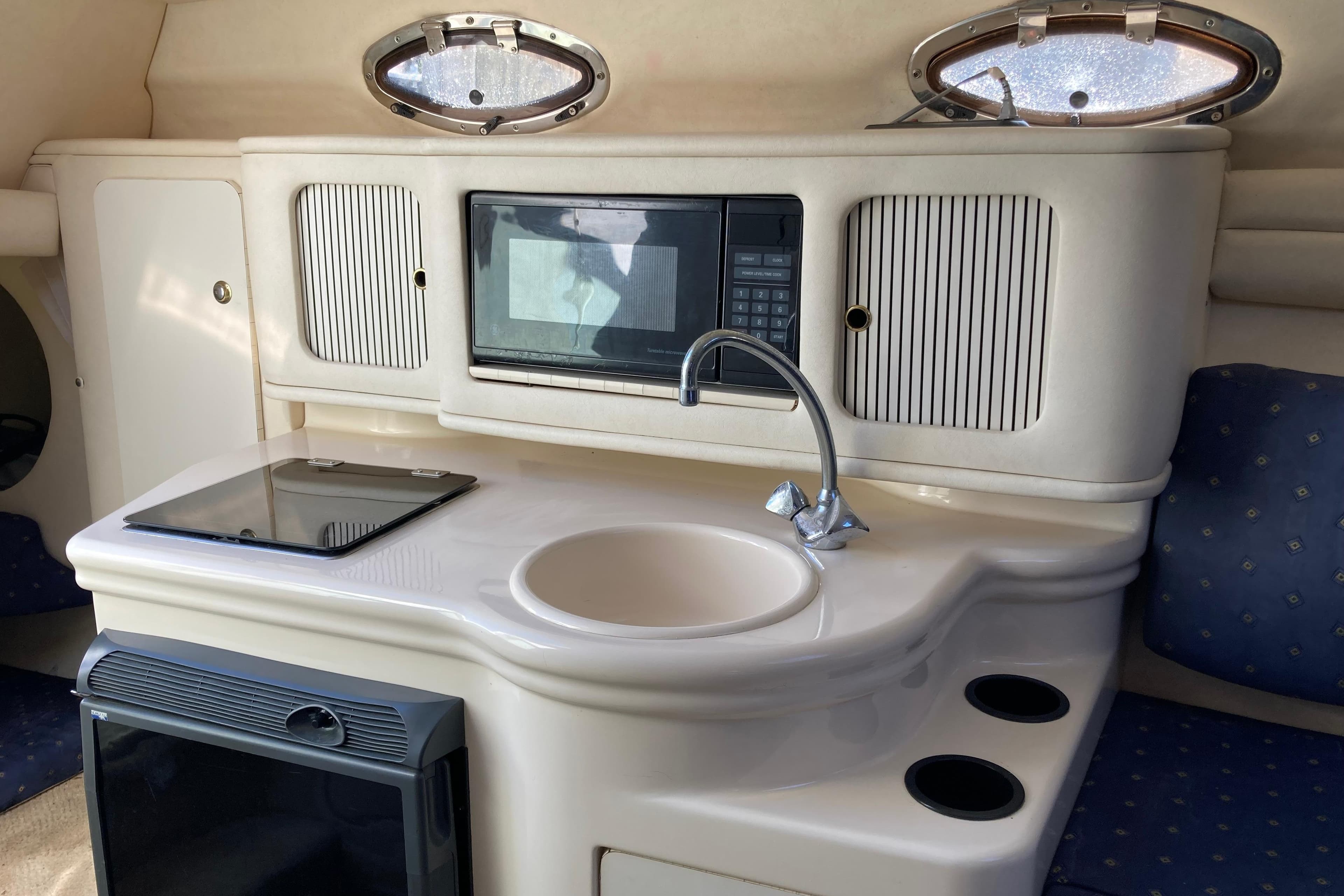 Interior of a 2002 Sea Ray Sundancer 260 boat featuring a compact kitchenette.