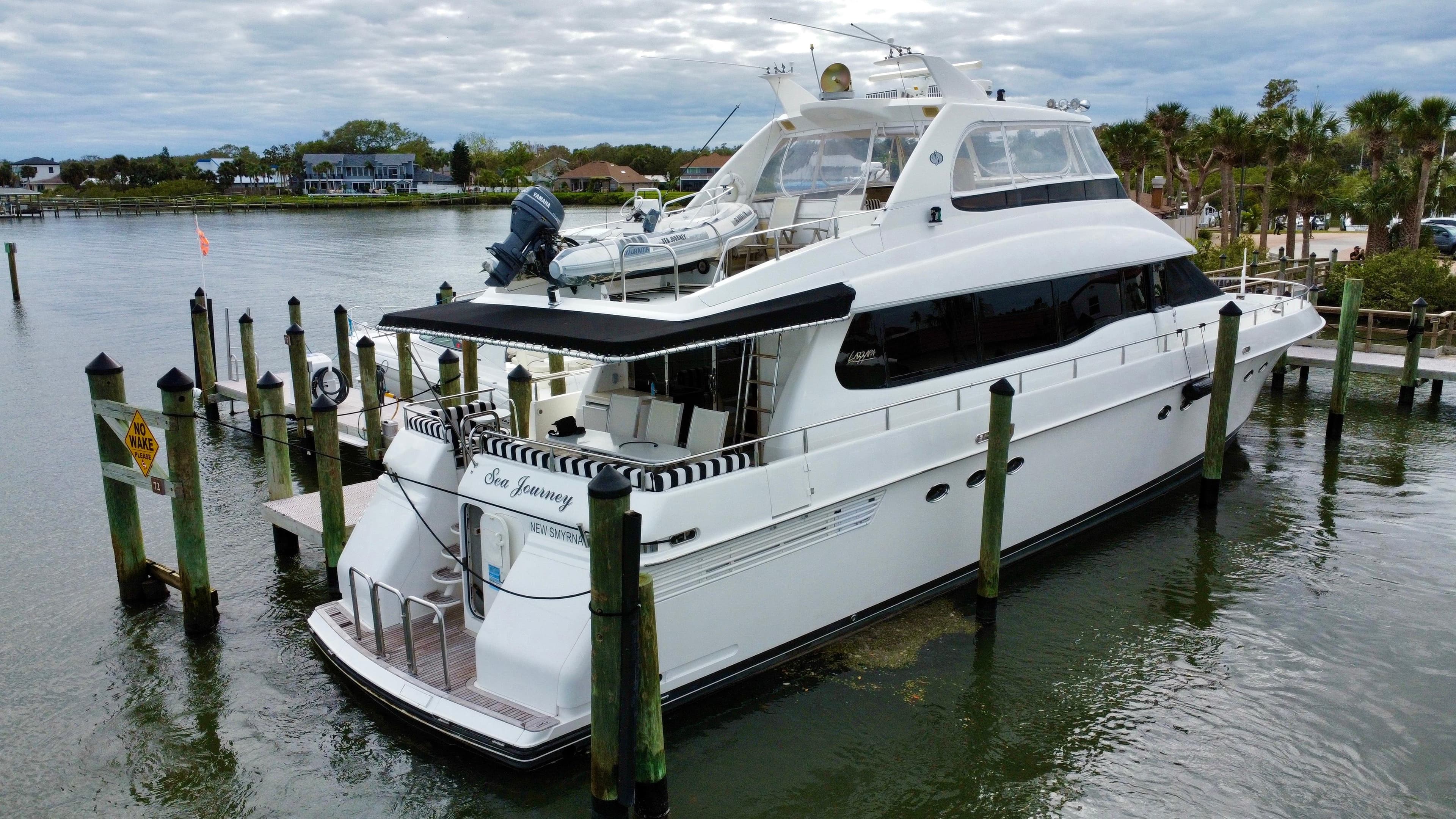 1997 Lazzara 76 yacht docked at marina, featuring sleek design and spacious deck.