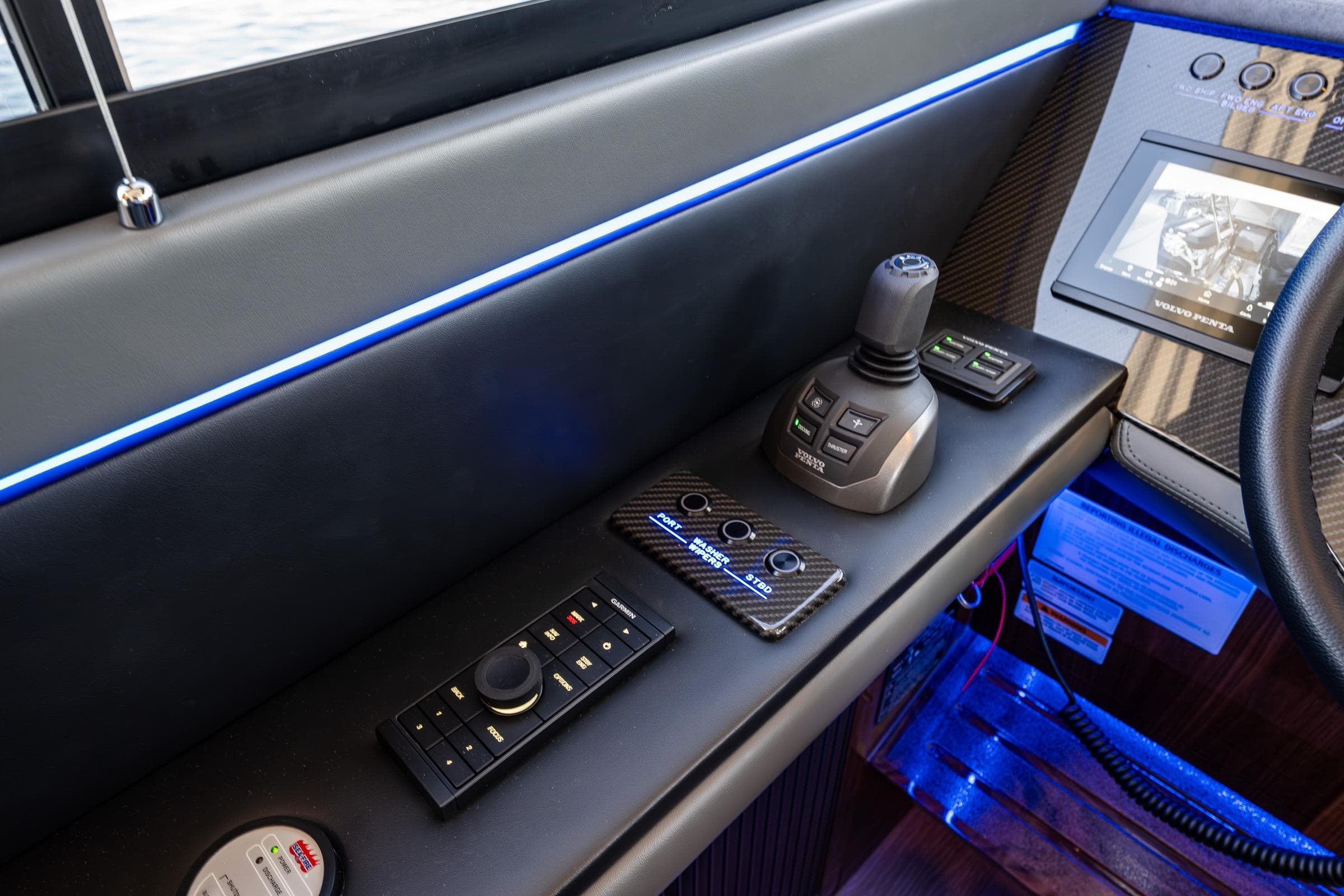 Control panel of 2025 Riviera 4600 Sport Yacht with joystick and digital display.