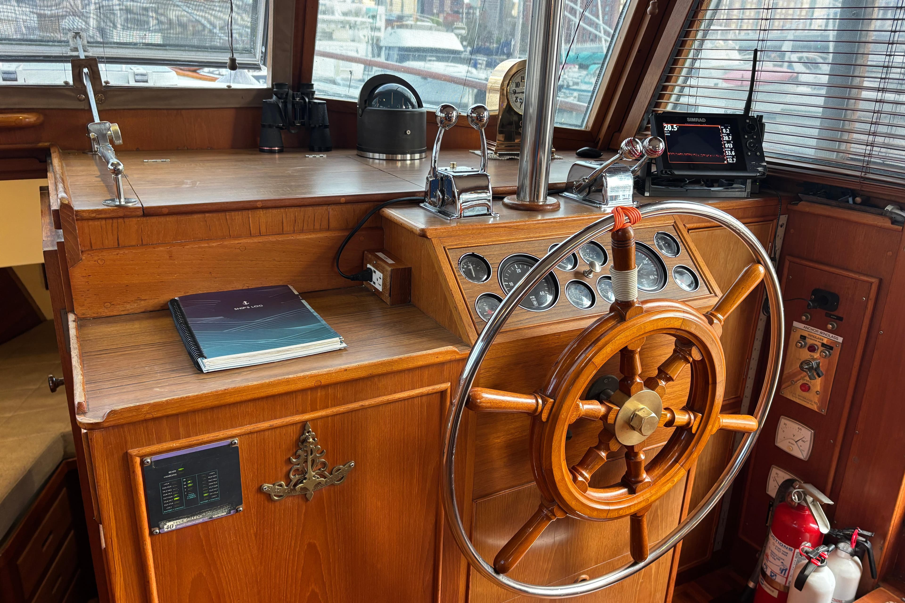 Helm of 1987 Grand Banks 42 Classic yacht with wooden wheel and navigation instruments.