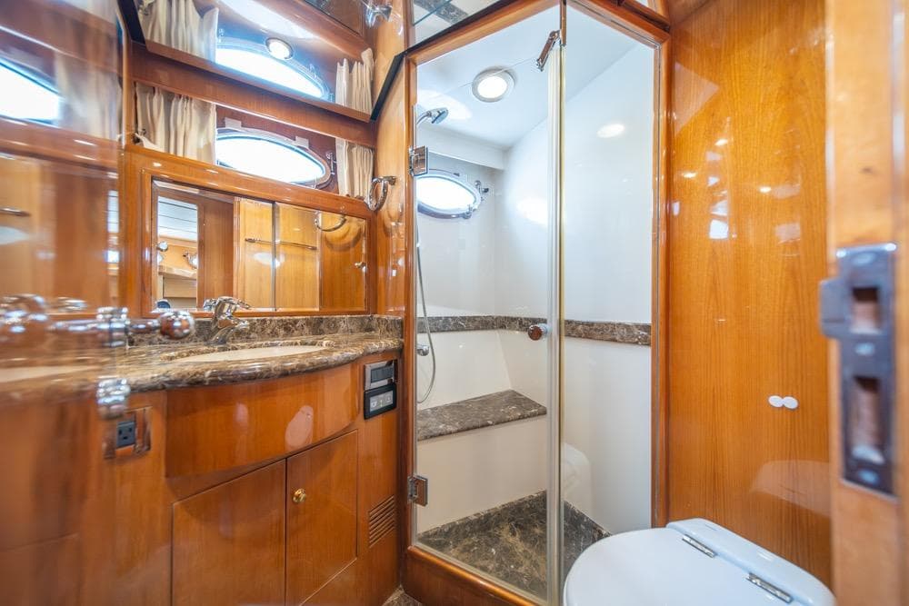 Luxurious bathroom in 2005 Ocean Alexander 64 Motoryacht with wood accents and marble surfaces.