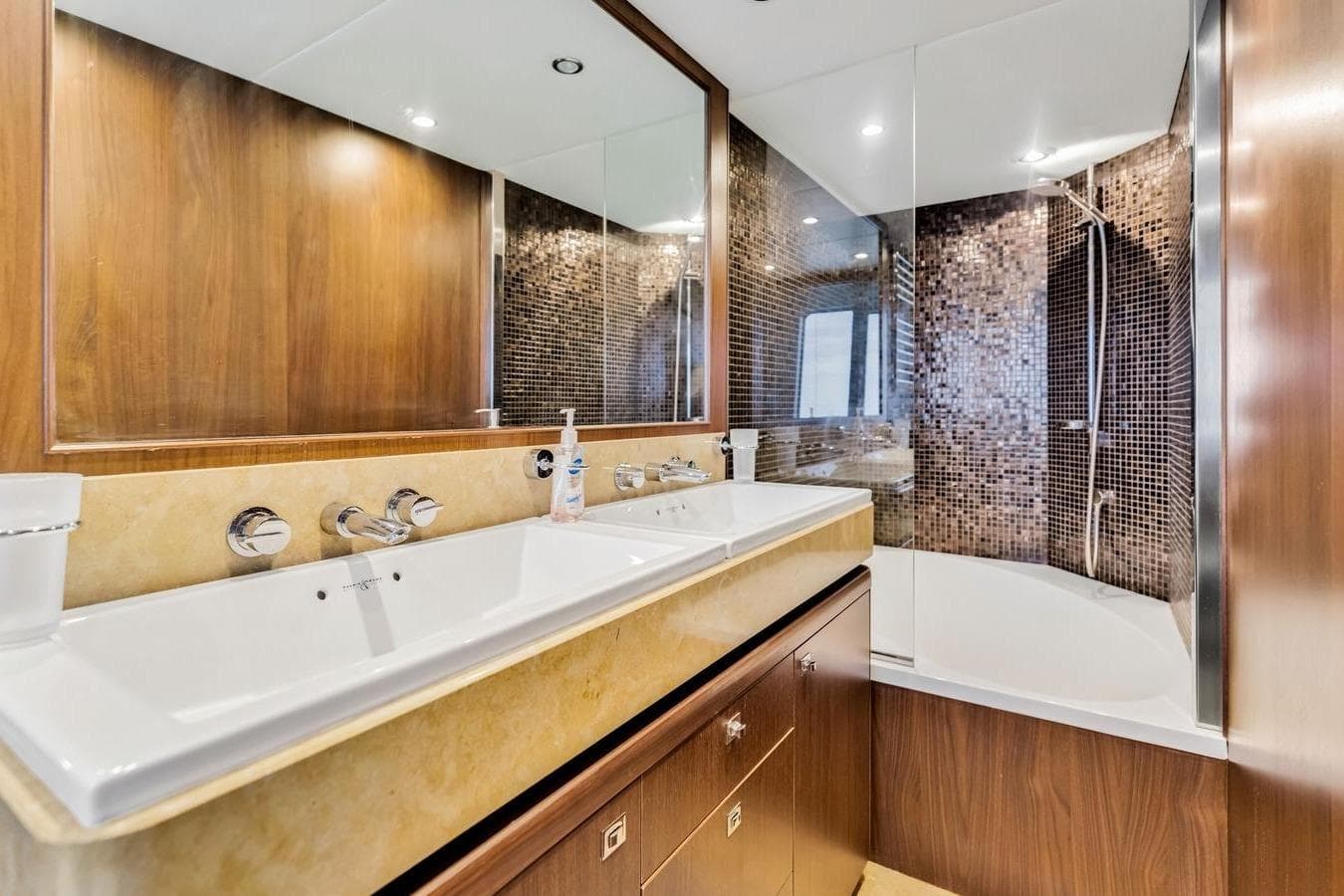 Luxurious yacht bathroom with dual sinks, modern fixtures, and elegant wood paneling.