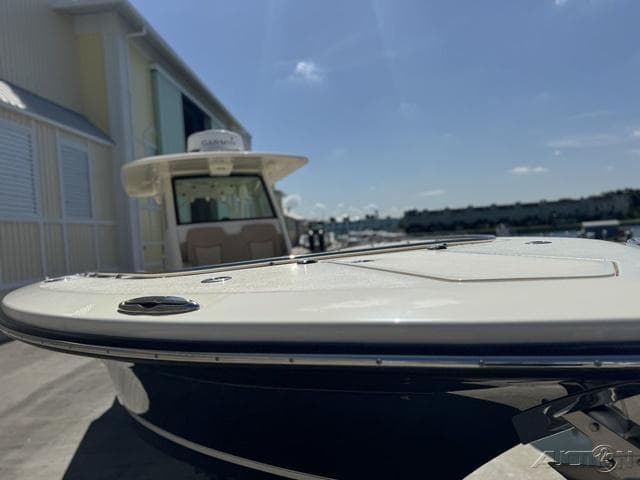 2022 Scout 330 LXF boat docked at marina under clear sky.