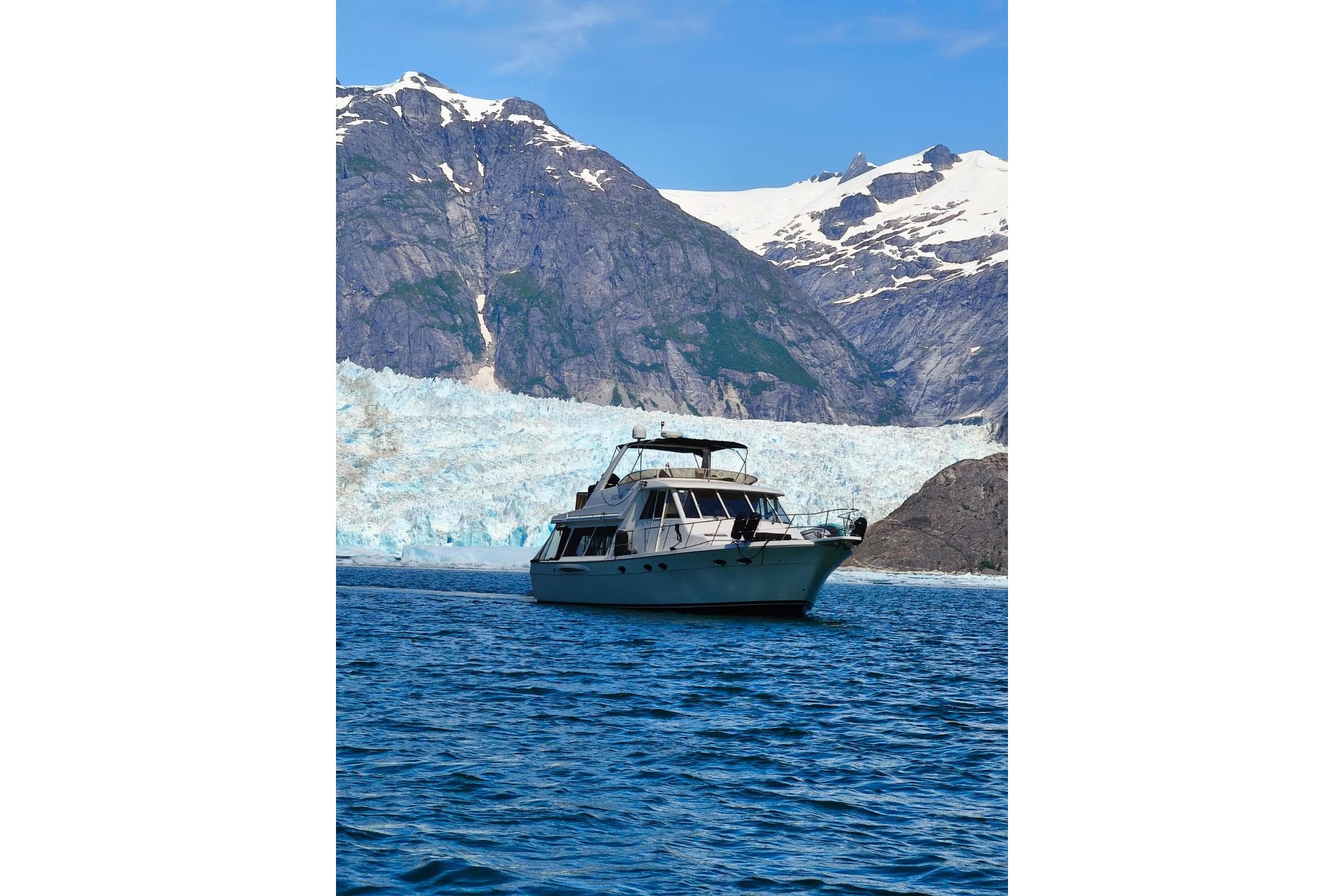 Meridian 490 Pilothouse yacht cruising near glacier and mountains, 2003 model.
