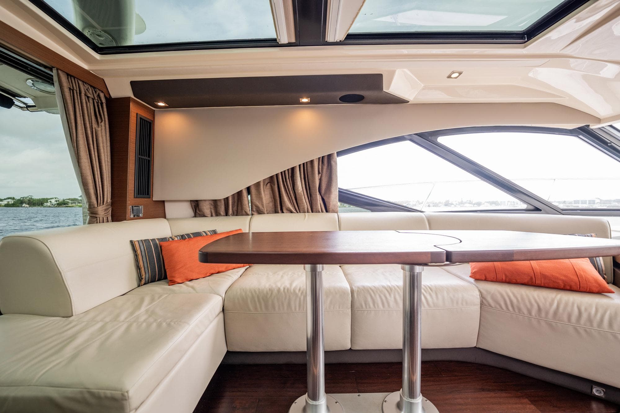 Luxurious interior of 2015 Sea Ray 510 Sundancer yacht with plush seating and elegant table.