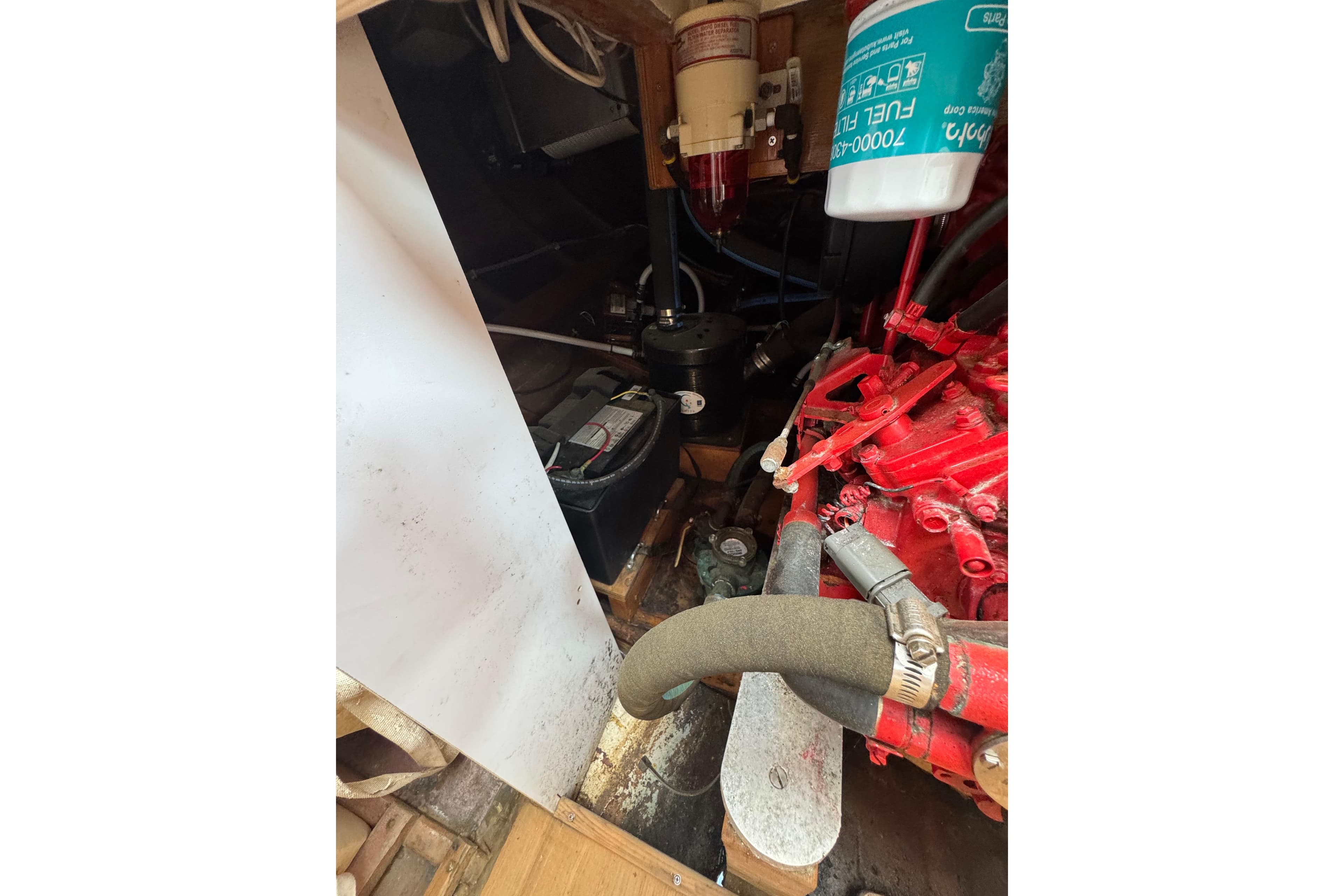 Engine compartment of 1979 O.Lie-Neilsen 44 Cutter Rigged sailboat, showing red engine and components.