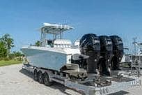 2007 Fountain 38 CC Tournament Edition boat on trailer with triple outboard engines.