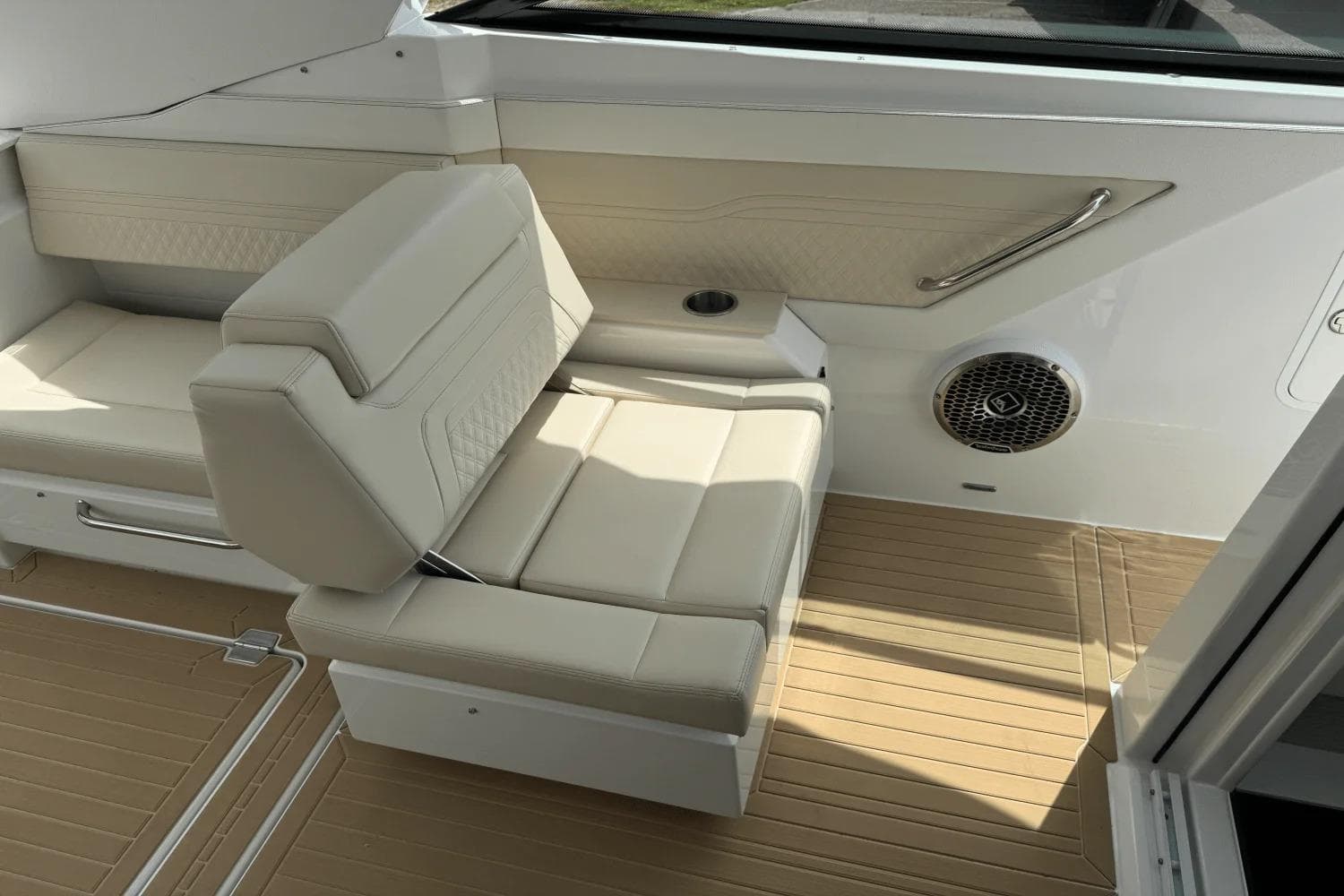 2026 Cruisers Yachts 34 GLS I/O interior with beige seating and speaker.
