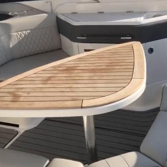 Luxurious interior of 2023 Sea Ray SLX310 boat with elegant wooden table.