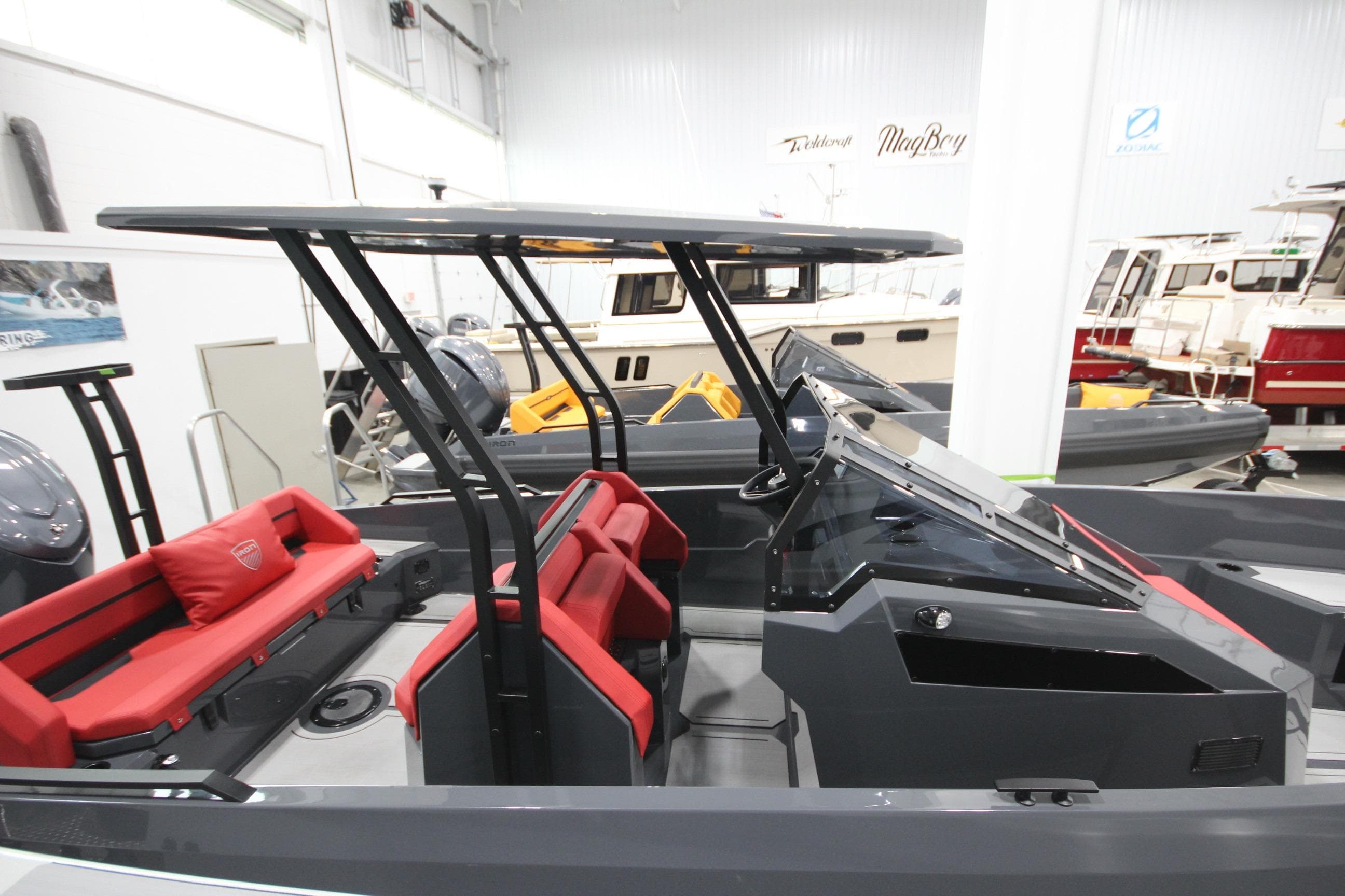 2026 Iron 827 T-Top boat with sleek design and red seating in showroom.