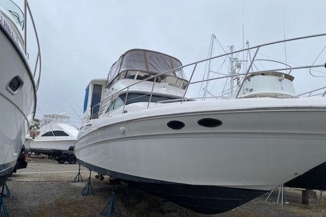 1999 Sea Ray 420 Aft Cabin yacht on stands, docked alongside other boats.