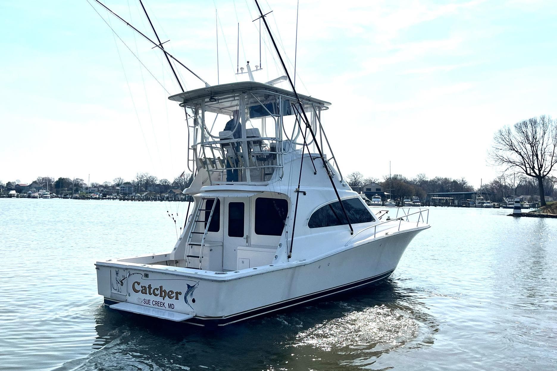 2003 Luhrs 40 Convertible boat on calm water, rear view with fishing rods.