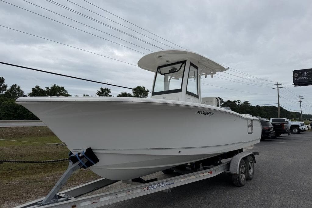 2018 Sea Hunt Ultra 255 SE boat on trailer, parked outdoors under cloudy sky.