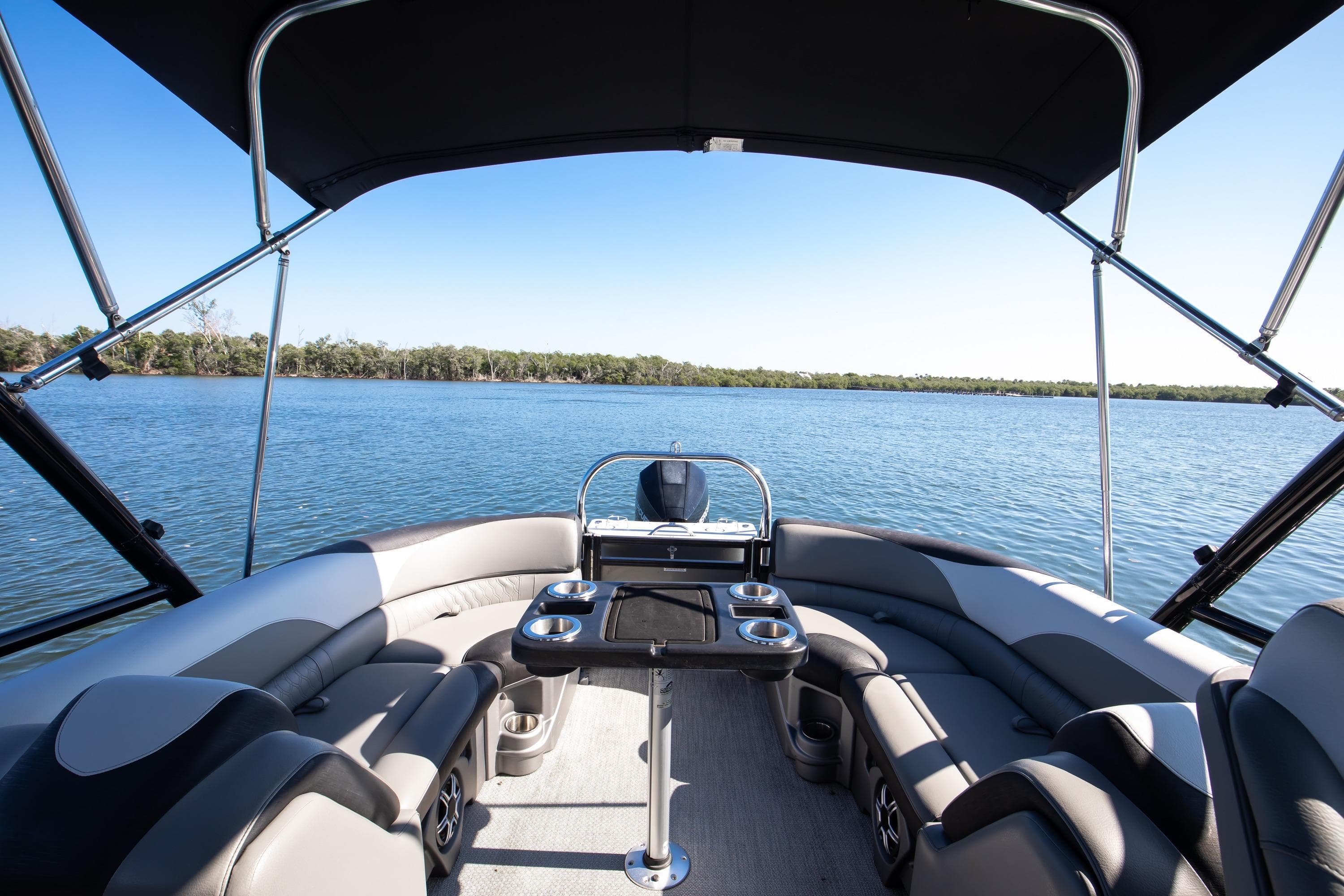 2021 Avalon LSZ Quad Lounger boat interior with lake view, featuring comfortable seating and canopy.