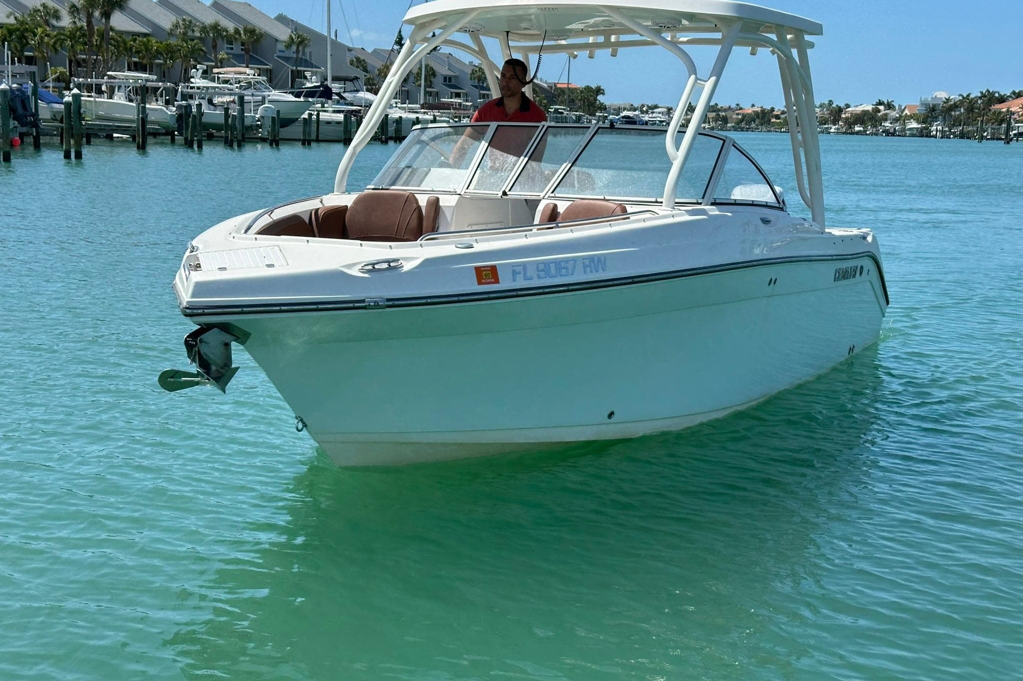 2019 Century 24 Resorter boat on clear turquoise water near marina.