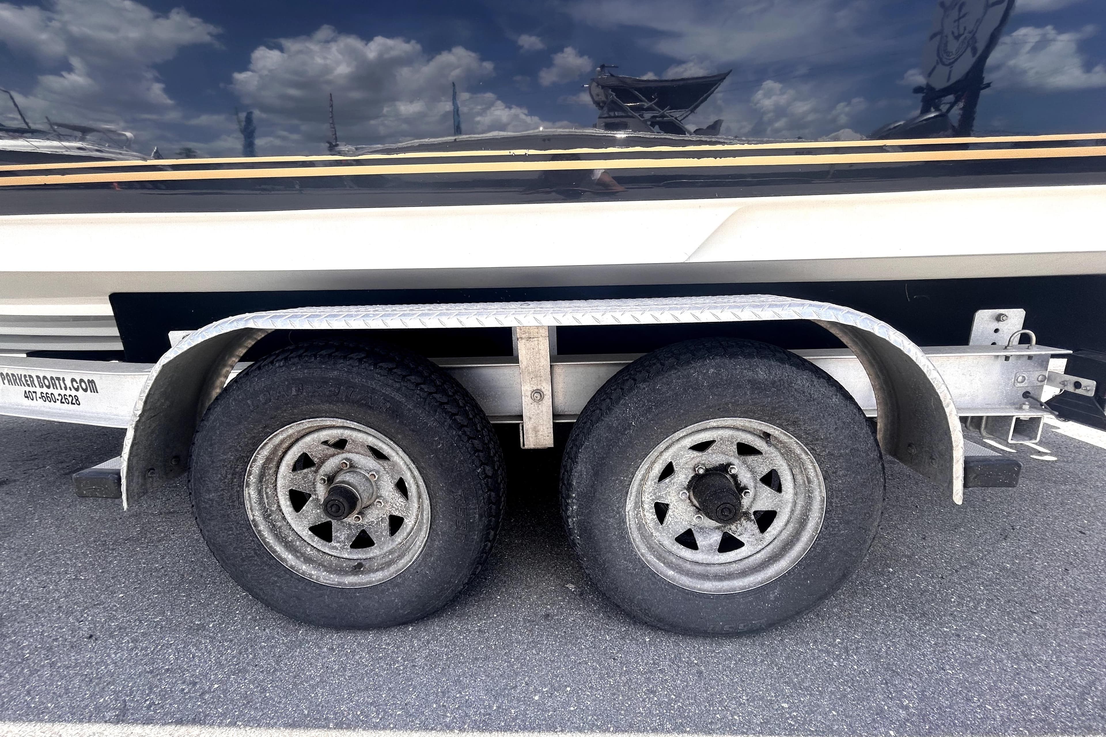 Trailer wheels of a 2006 Sea Ray 250 Amberjack boat on asphalt.