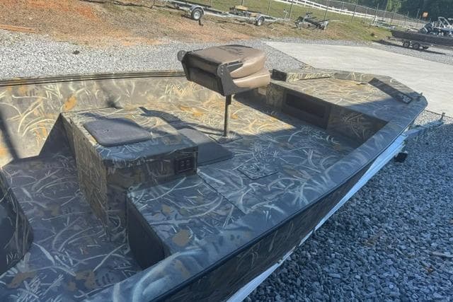 2026 War Eagle 2170 Blackhawk boat with camouflage design on gravel surface.