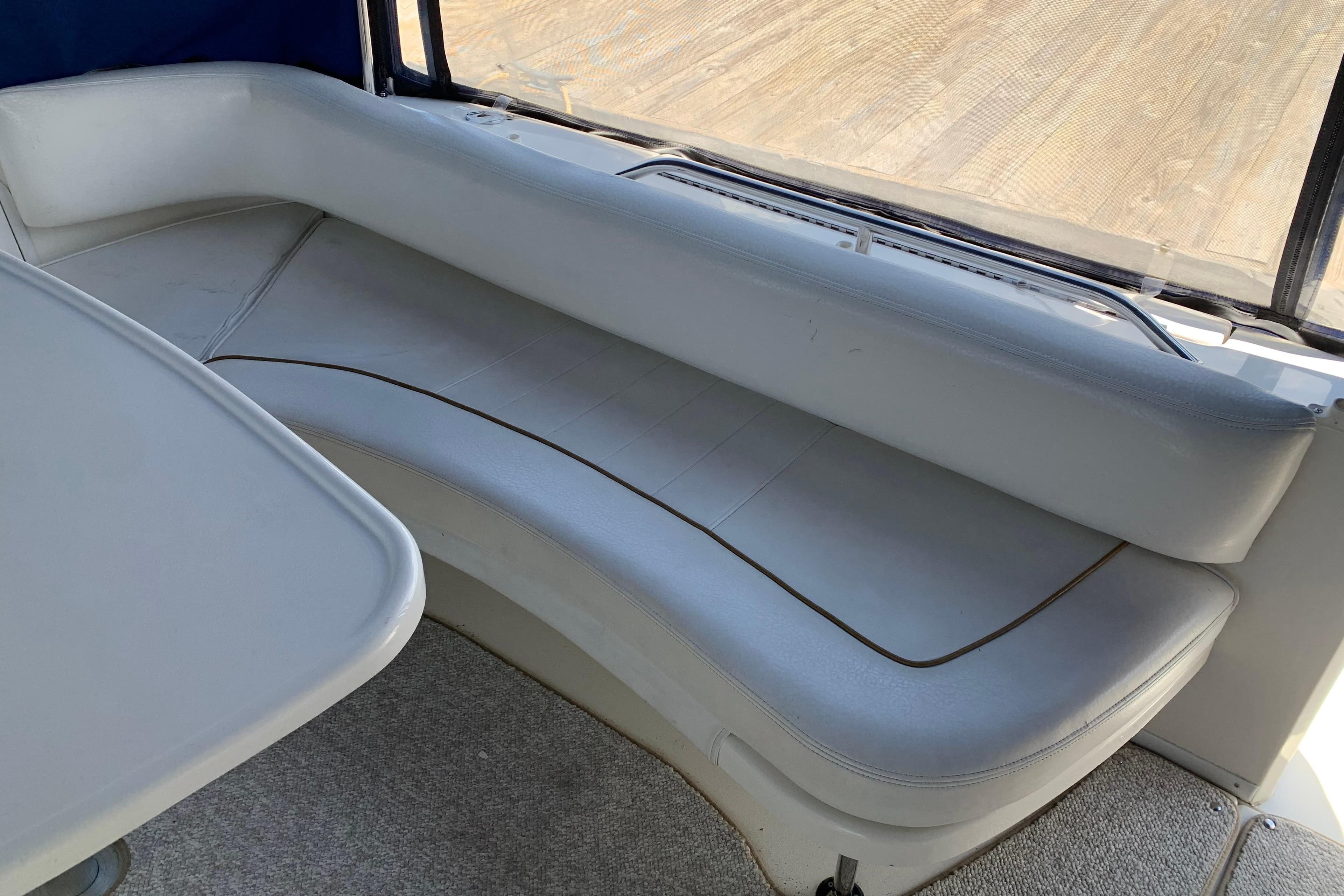 Interior seating of 2000 Sea Ray Sundancer 310 boat with white upholstery.