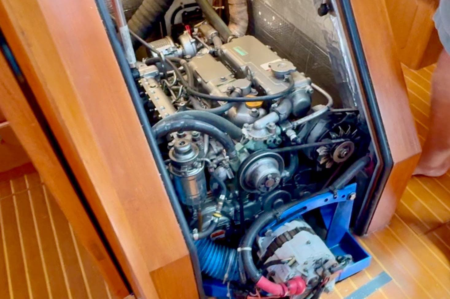 Engine compartment of a 2005 Outbound 46 yacht, showcasing mechanical components and wooden interior.