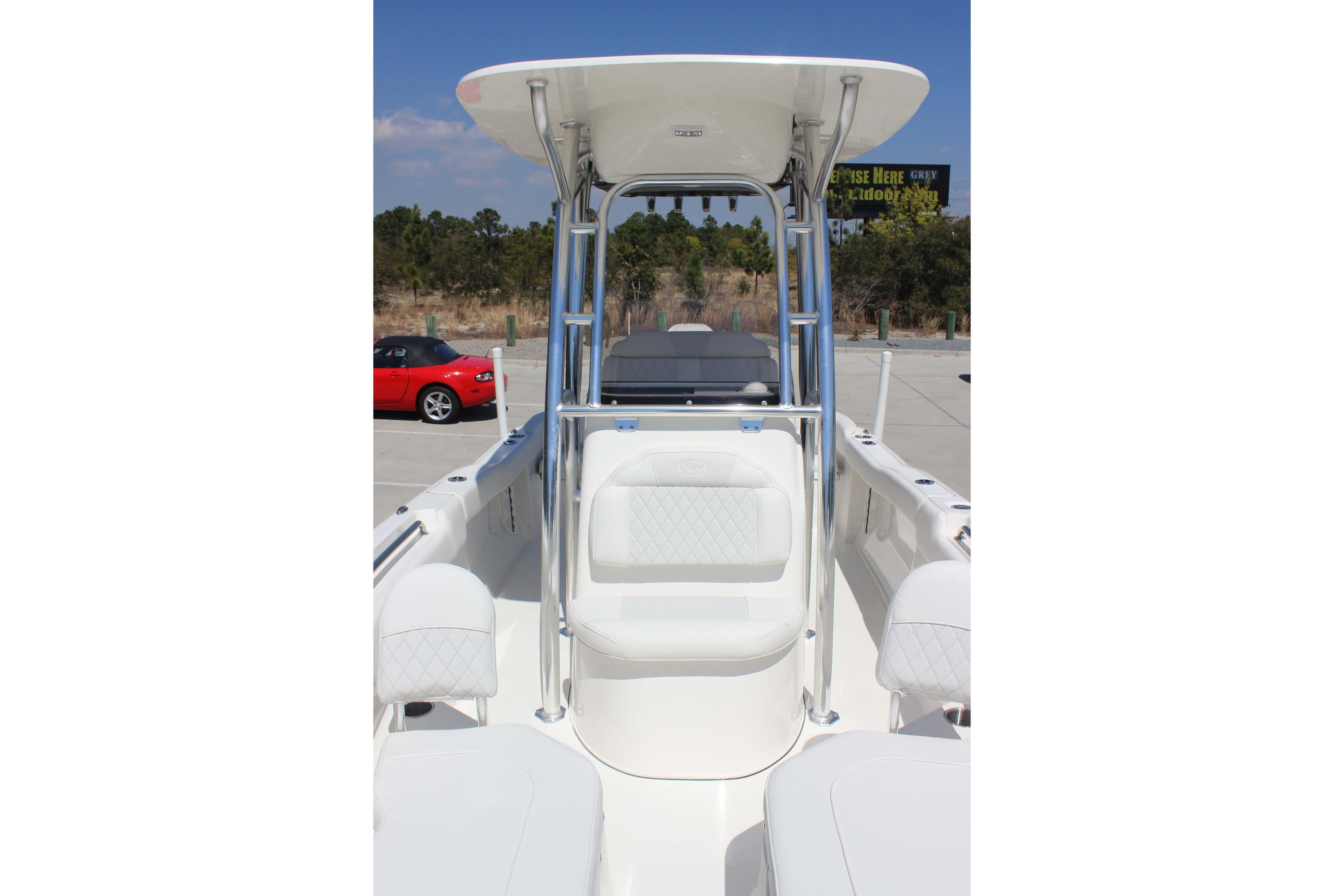 2026 Key West 203 FS boat interior with seating and T-top in a parking lot.