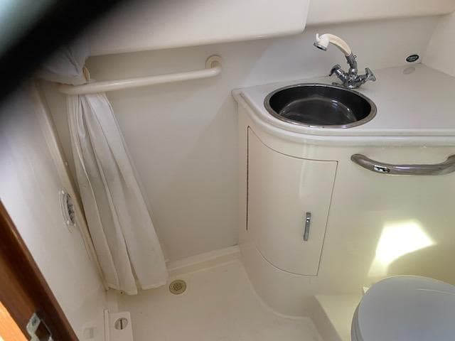 Compact bathroom in a 2000 Cabo 35 Express boat with sink and toilet.
