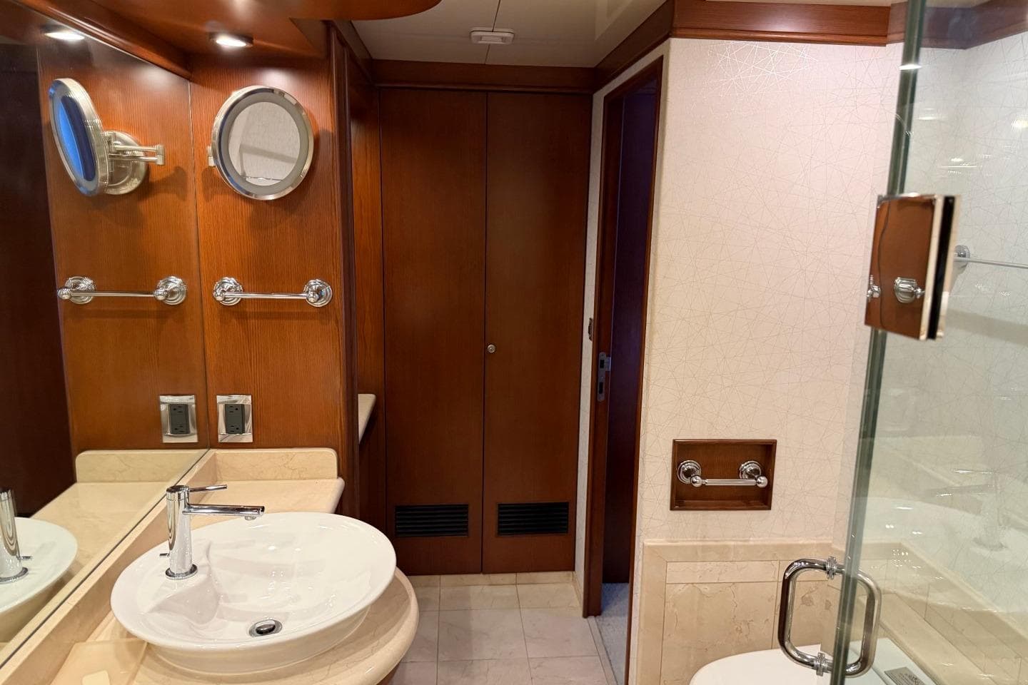 Luxurious bathroom interior of 1990 Heesen 144 yacht with wooden accents and modern fixtures.