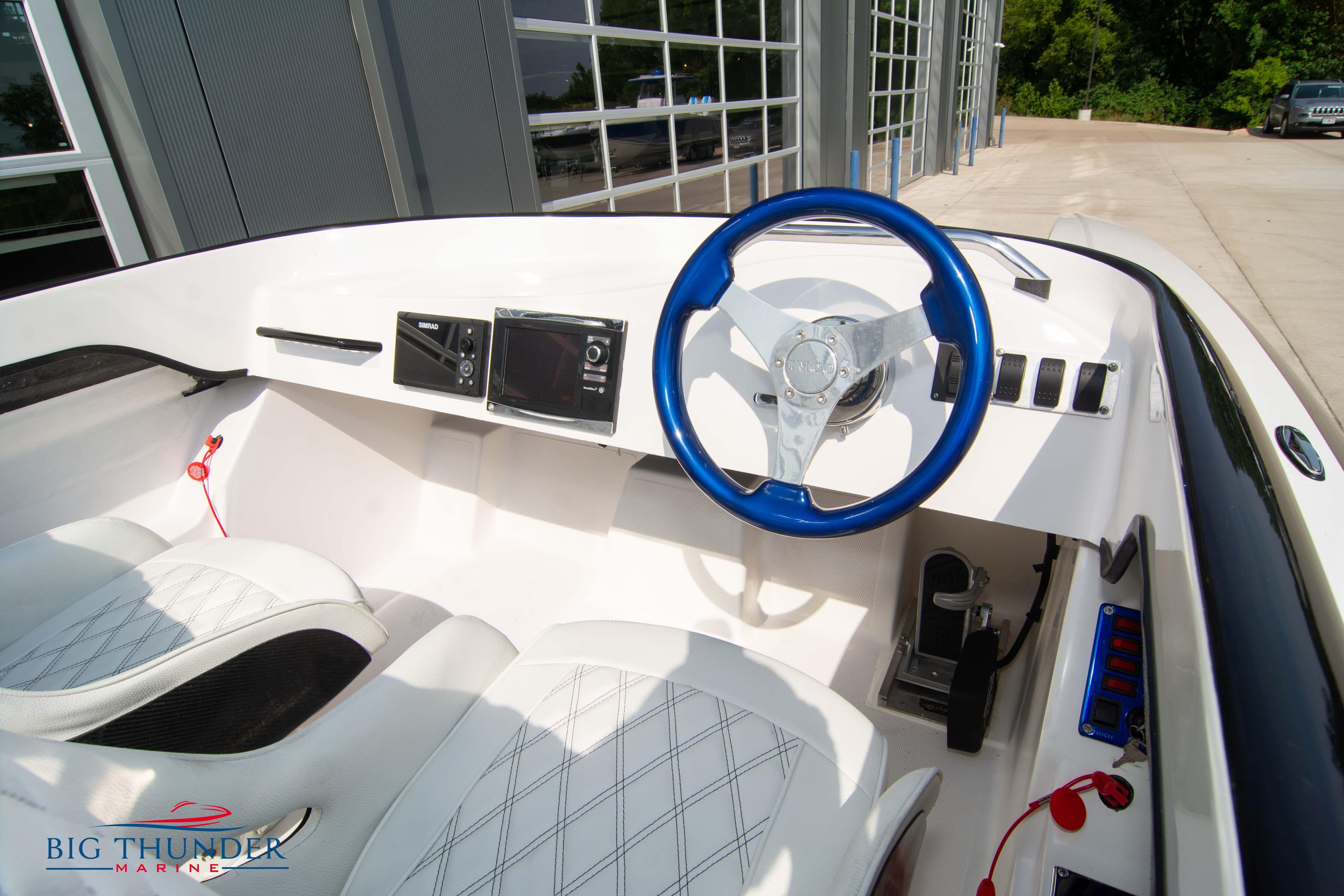 2019 Spectre Screaming Eagle 22 Talon boat interior with blue steering wheel and white seats.