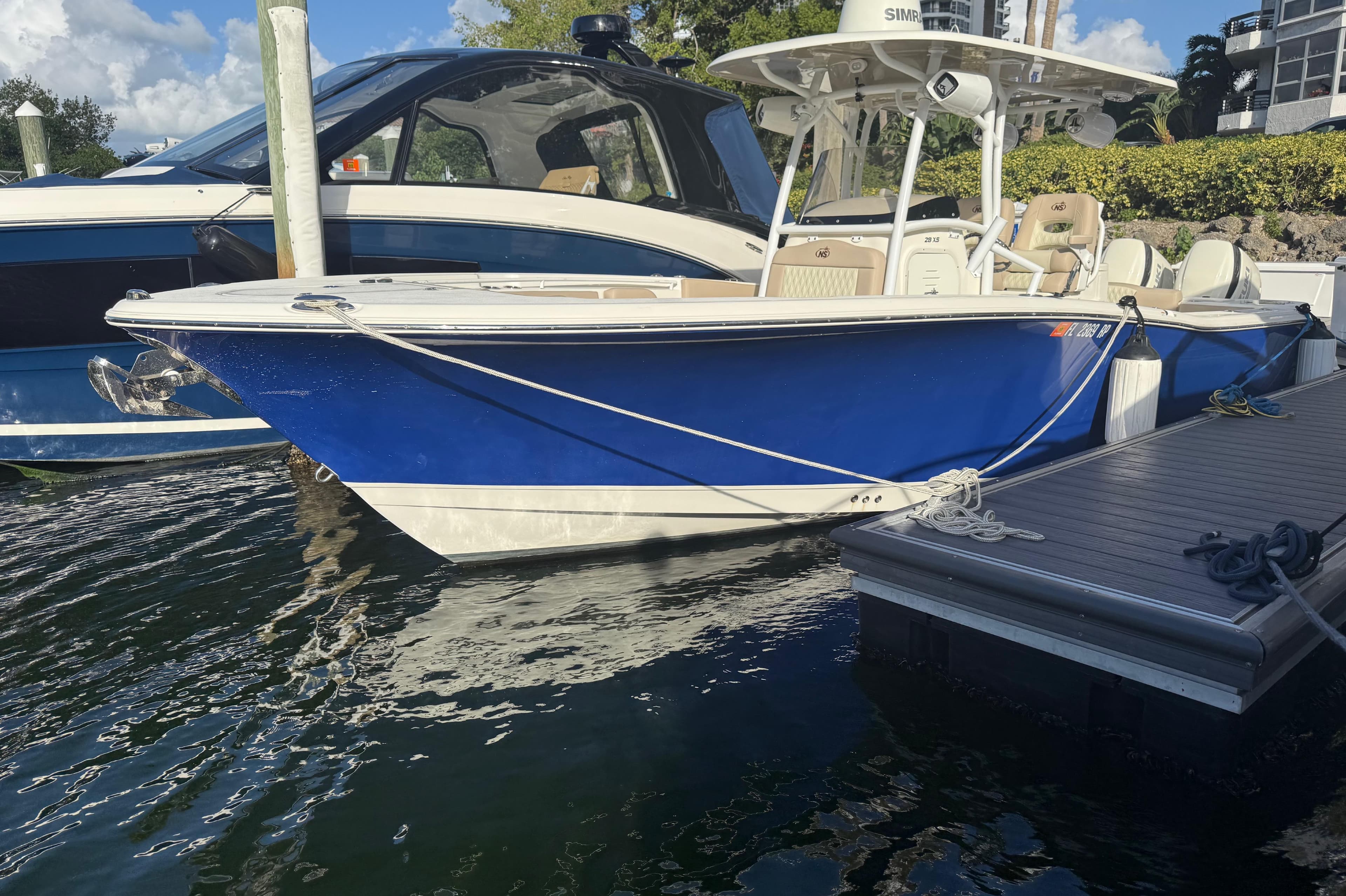 2018 NauticStar 28 XS boat docked, featuring a sleek blue hull and modern design.