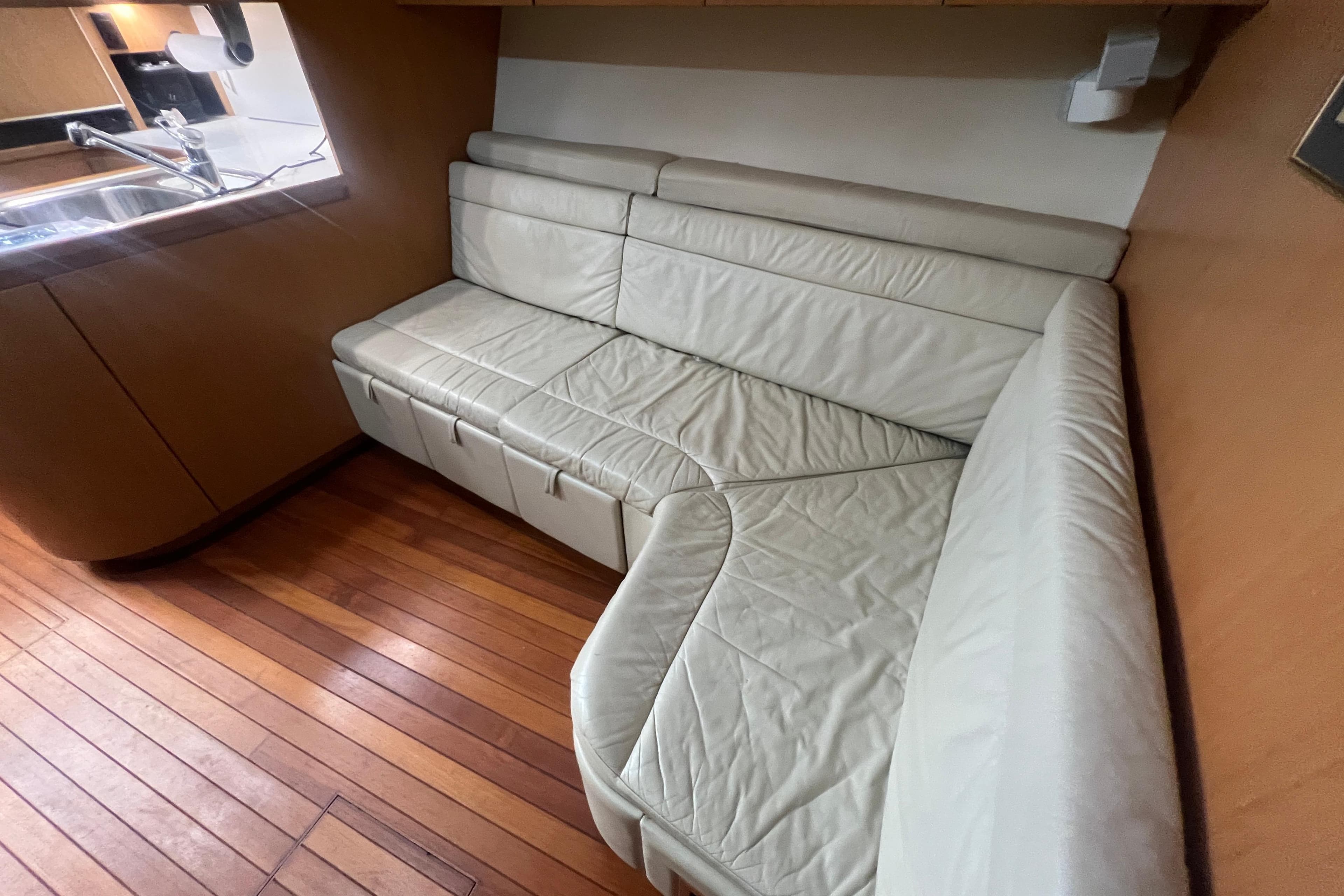 Luxurious leather seating in 1996 Tiara Yachts 4300 Open interior with wooden flooring.